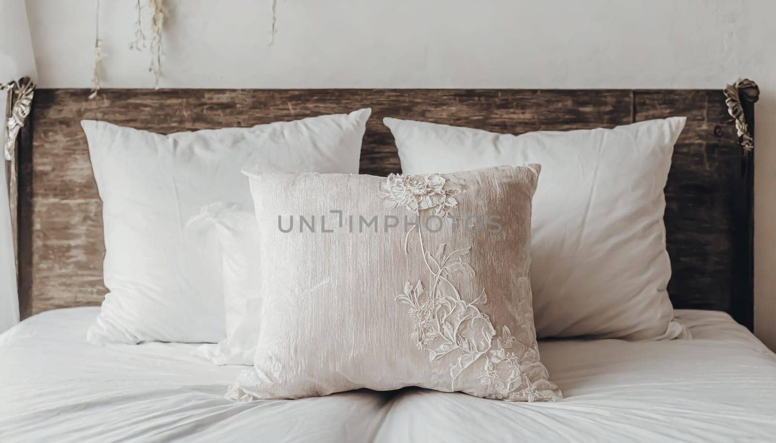 Clean Bedding sheets and pillow on natural wall room background. White bedding and pillow in hotel room. White pillows on empty bed.