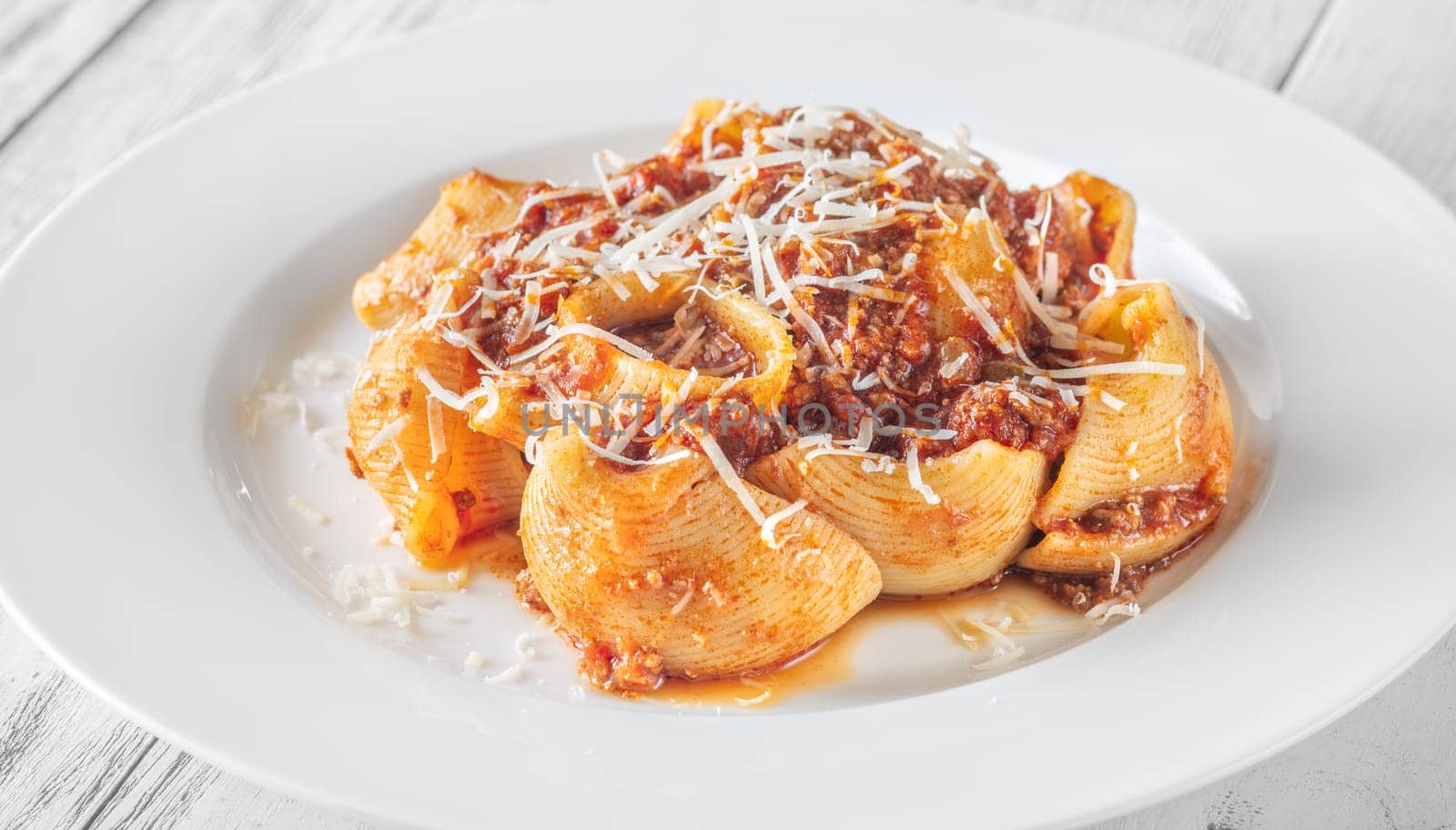 Portion of lumaconi pasta with bolognese sauce