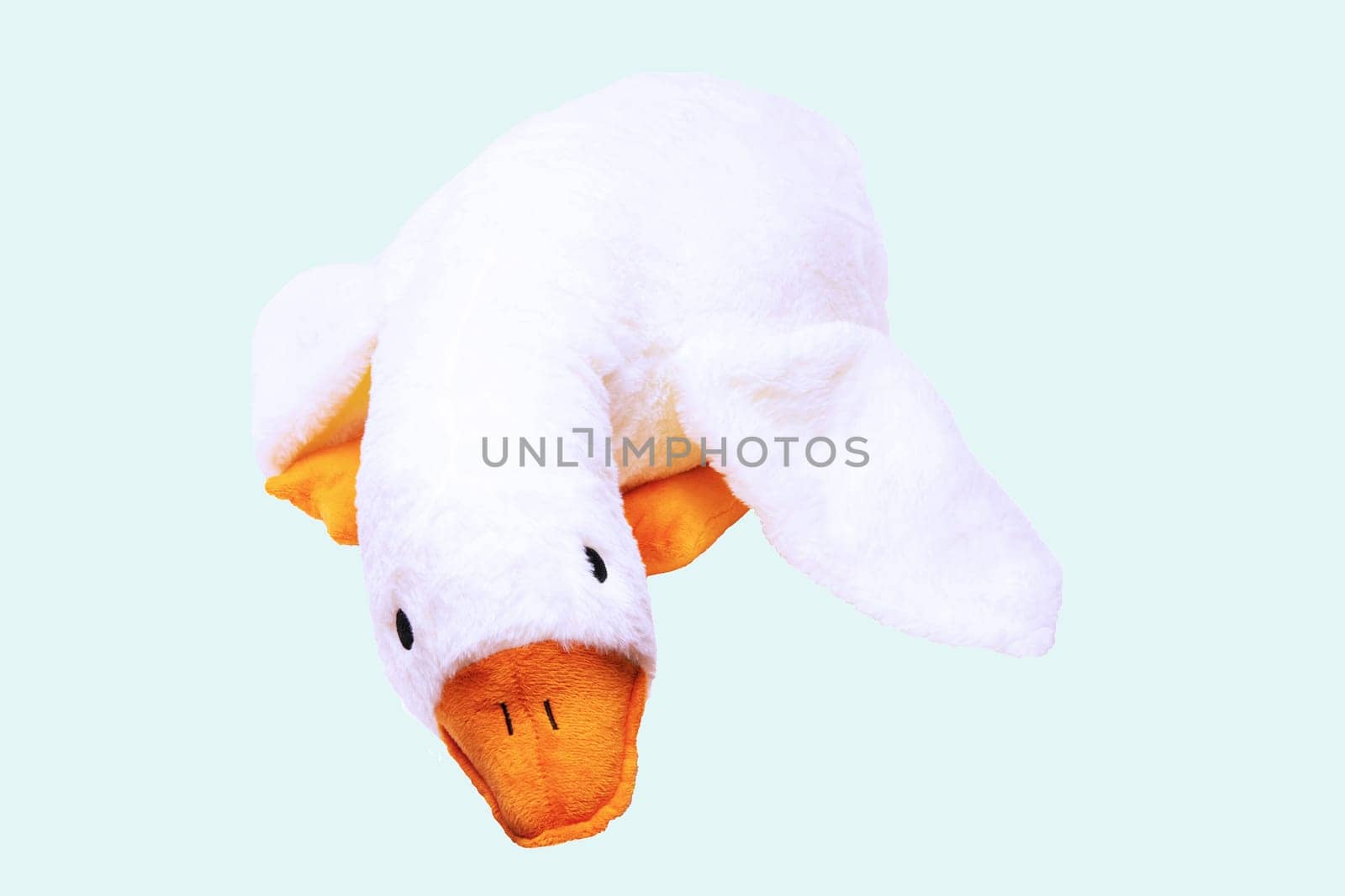 Childrens toy stuffed animals. Soft white plush toy duck for kids isolated on a light blue background. Duck teddy toy. White duck for playing.