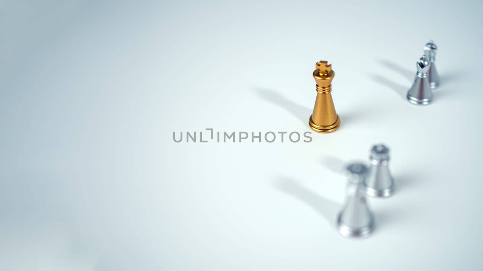 Golden king chess on the board in front of silver chess pieces on white background with copy space, Leadership, fighter, business leadership, competition, confrontation, and business strategy concept.