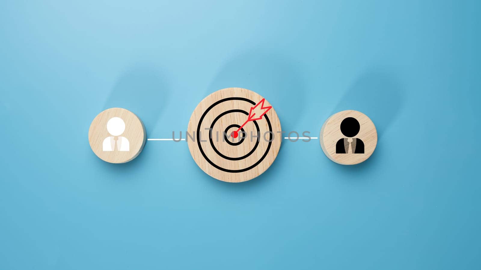 Circular wood with printed target icons and business symbols on light blue background, business goals and objectives concept, business competition, Customer relationship management concept.