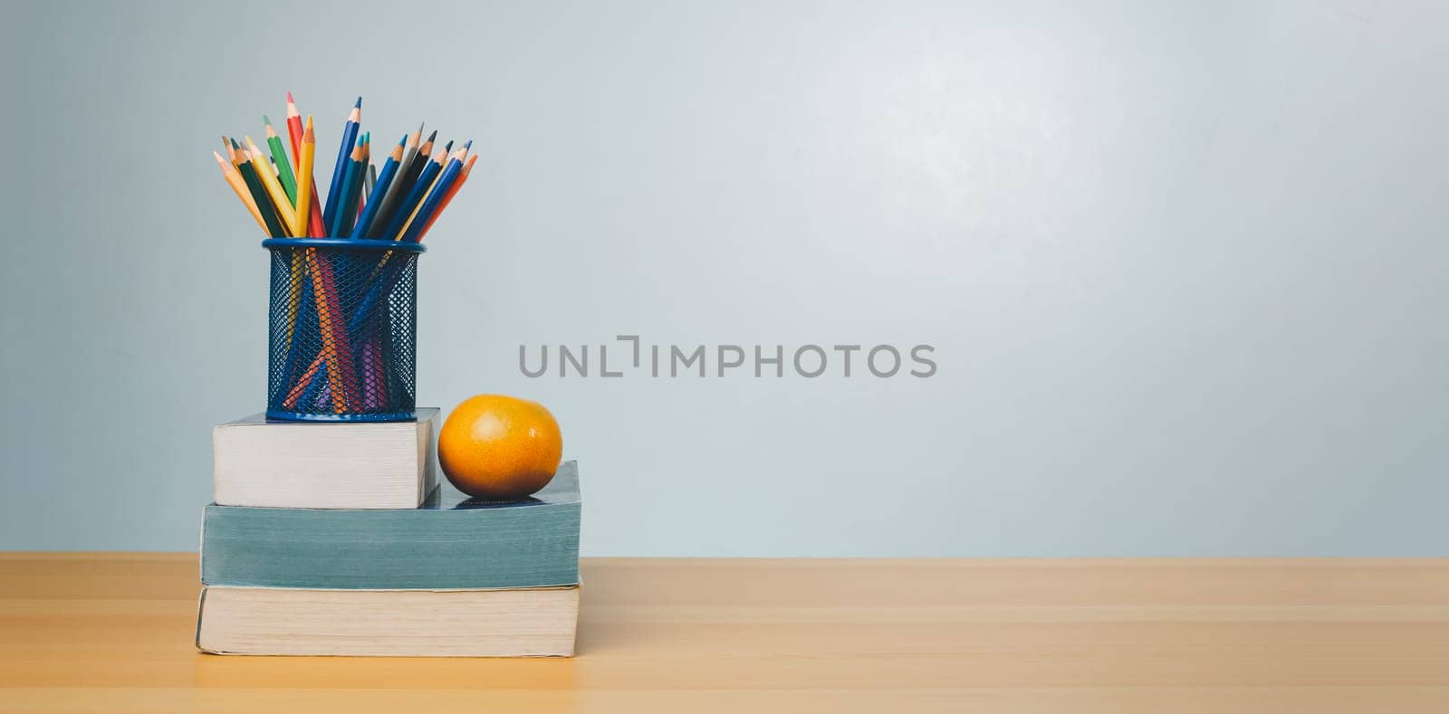 Stack of colorful textbooks and a glass of bright pencils on a white background, Concept of education, training, School tools, workspace, copy space, Banner design education concept background.