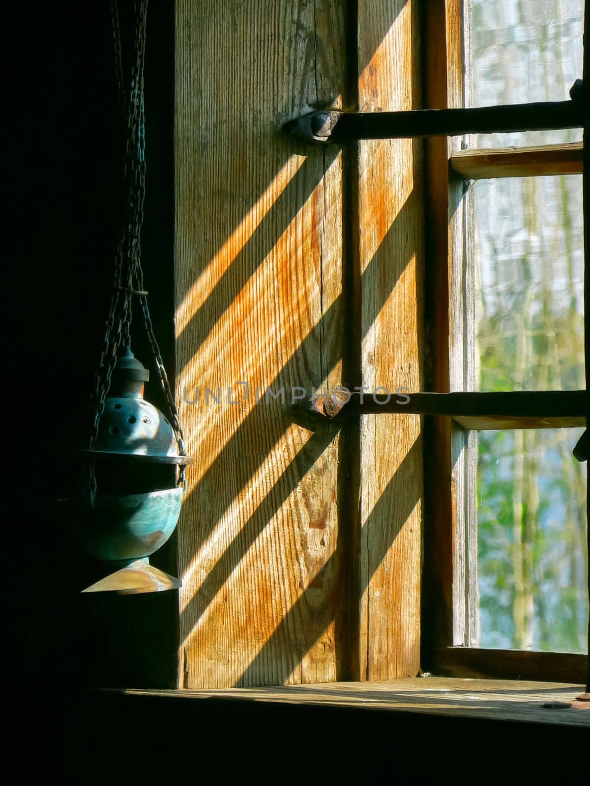 Lamp hanging at the wooden window with bars. Lamp hanging at the wooden window with bars.
