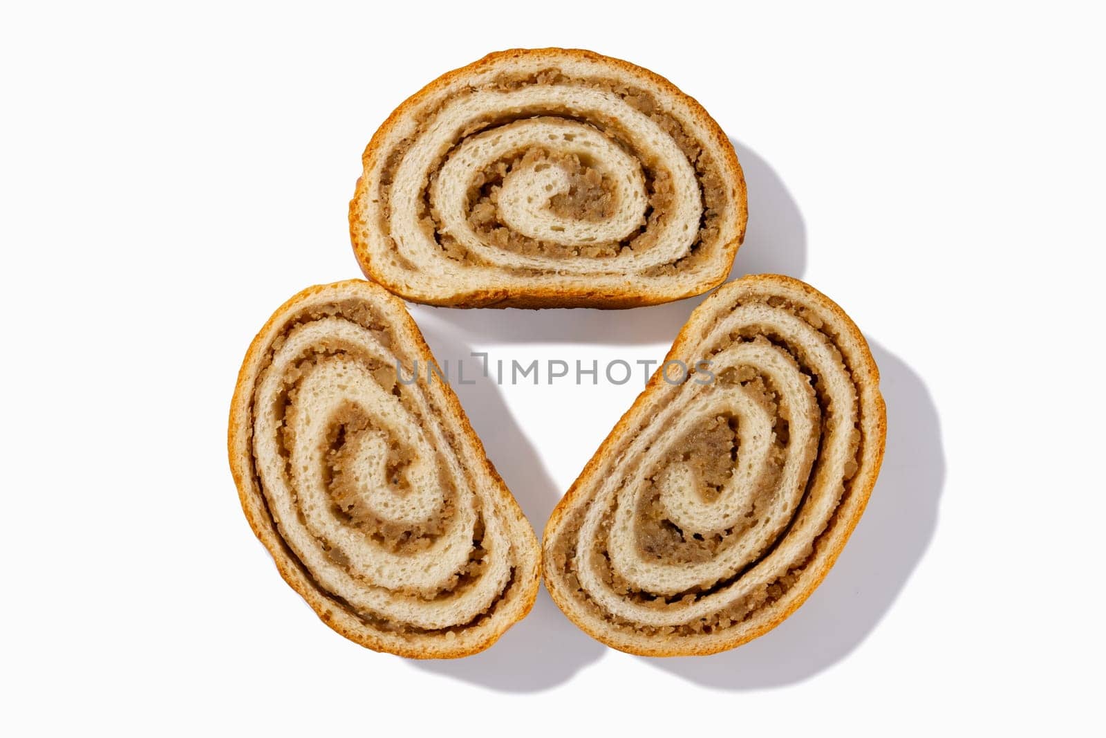 Enjoy three slices of German nut bread, each boasting crunchy walnuts and a golden-brown crust, set against a pristine white backdrop