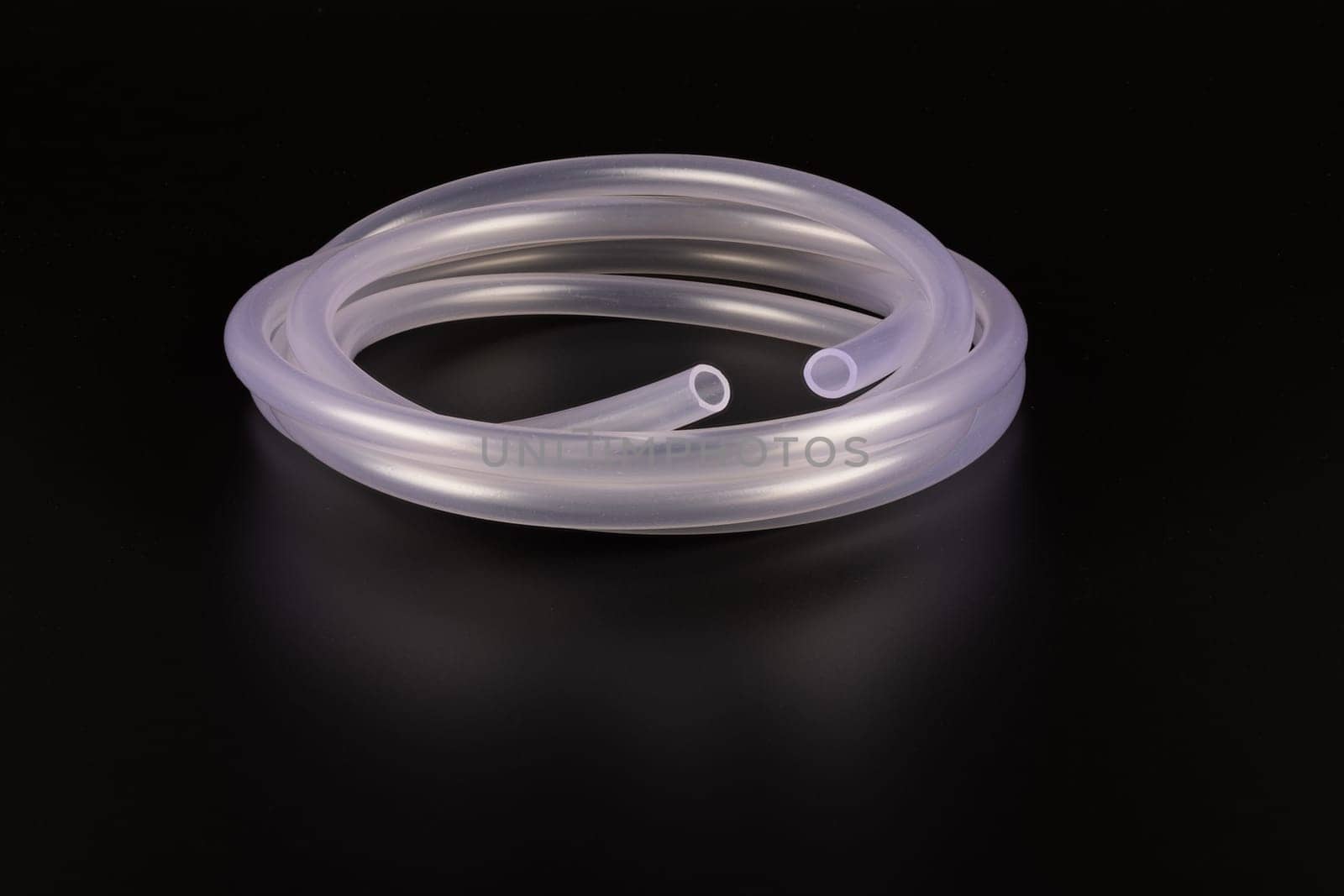 transparent plastic tube coil on black background.