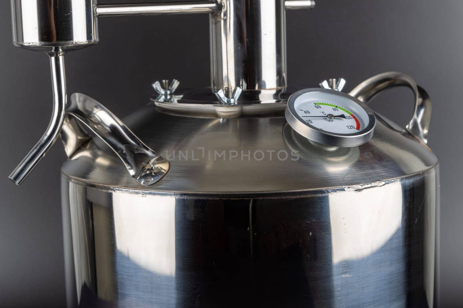 brand new stainless steel alcohol machine or moonshine still on black background.