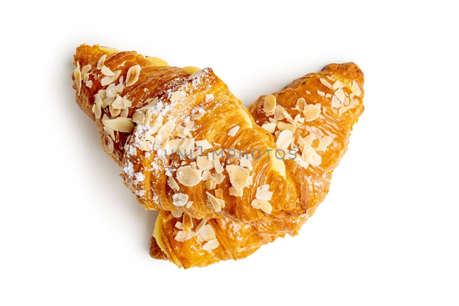 Indulge in the luxurious sight of two croissants filled with aromatic vanilla cream and adorned with crunchy almond flakes, elegantly stacked on white