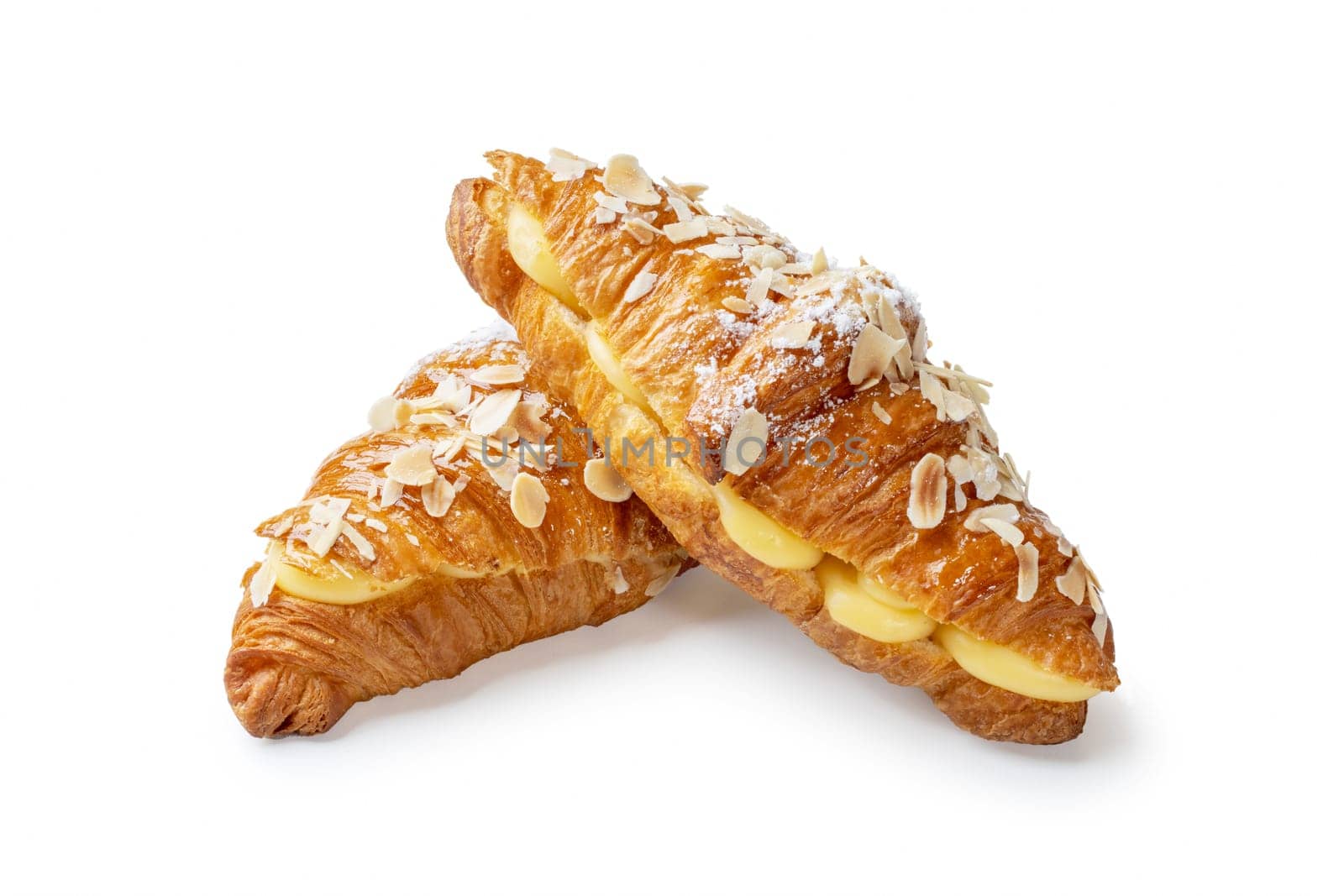 Indulge in the luxurious sight of two croissants filled with aromatic vanilla cream and adorned with crunchy almond flakes, elegantly stacked against a pristine white backdrop