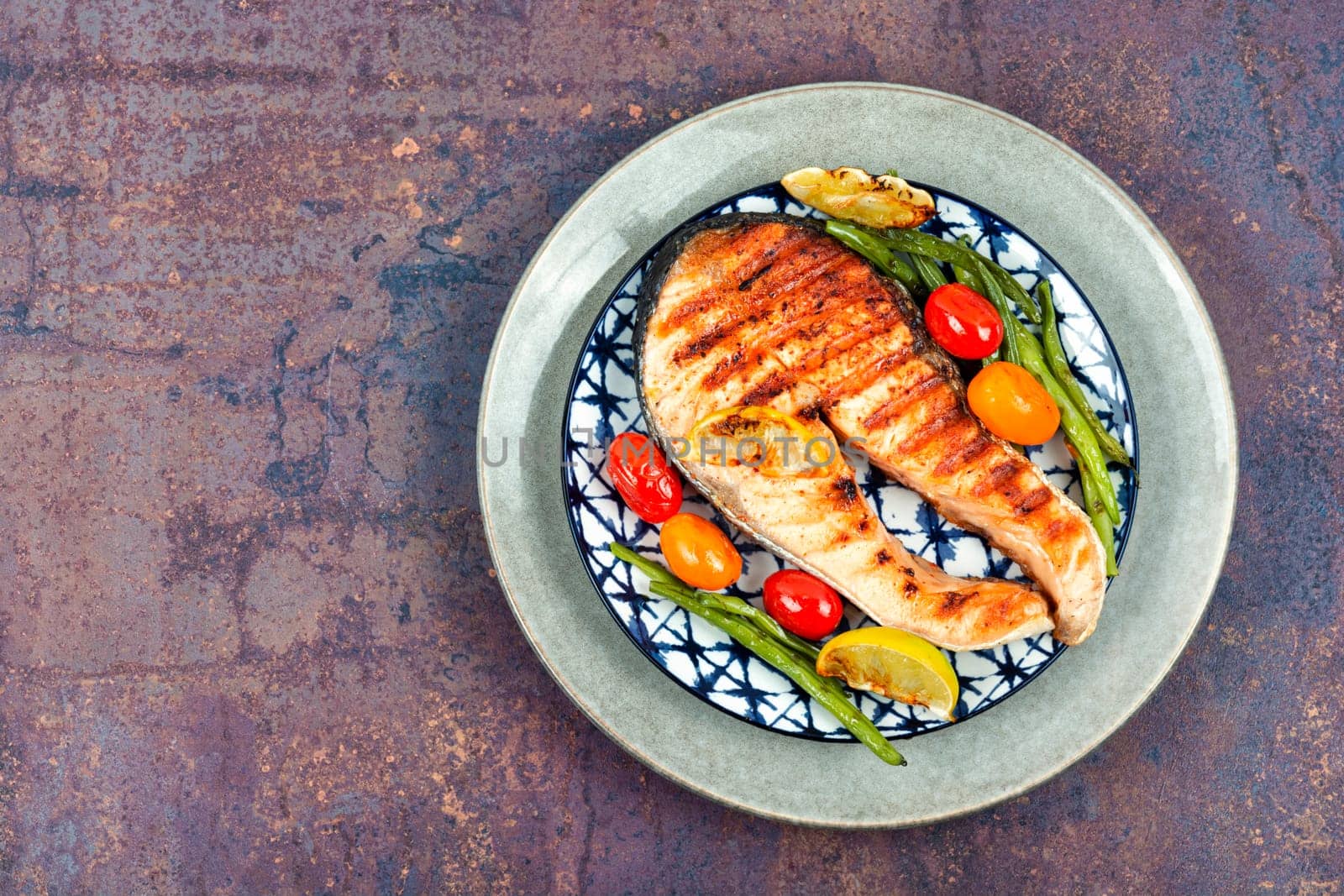 Grilled salmon steak with grilled vegetables, fried fish. Space for text.