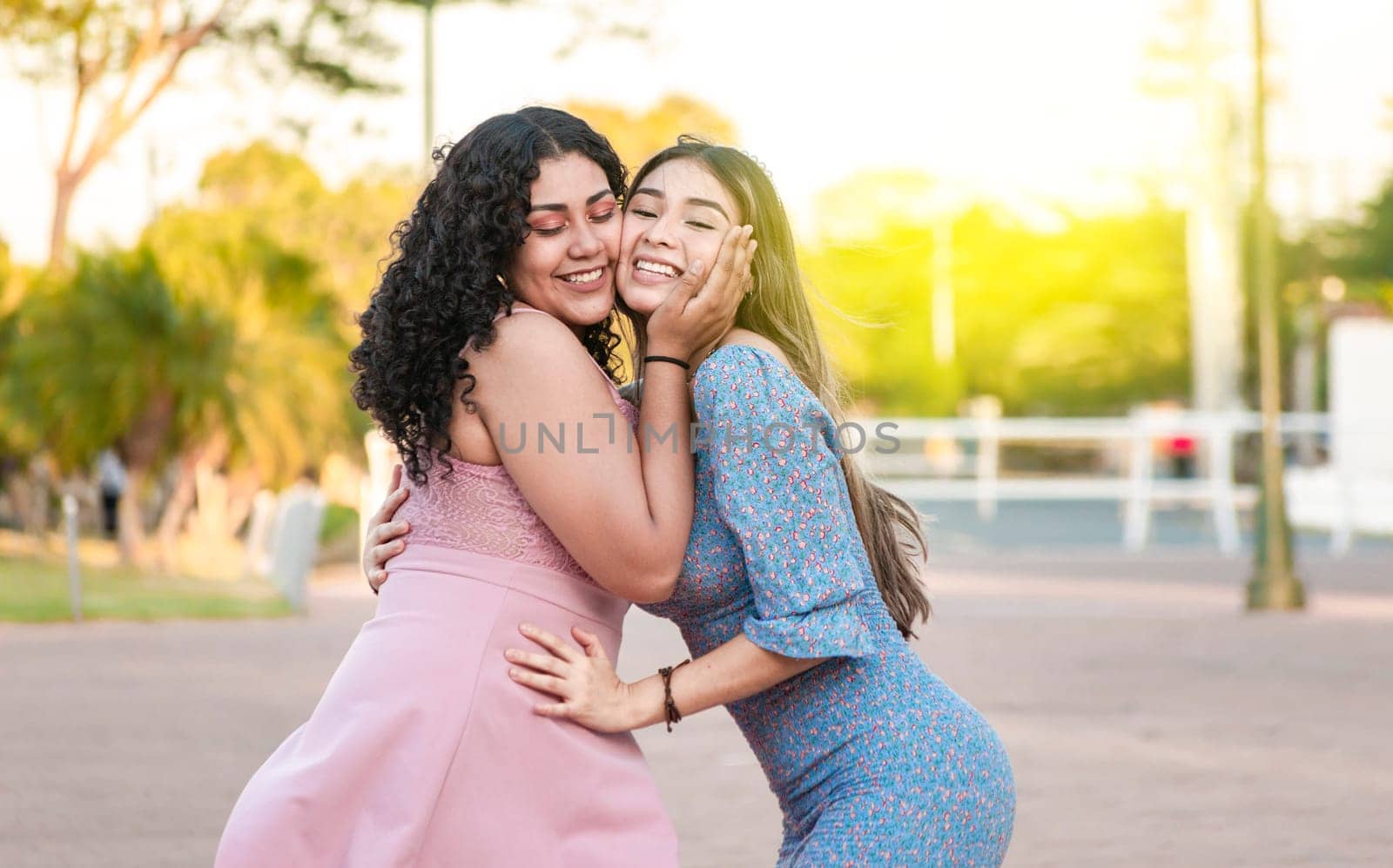 Two female friends hugging in front outdoors, girl friends hugging and enjoying life, women friendship concept