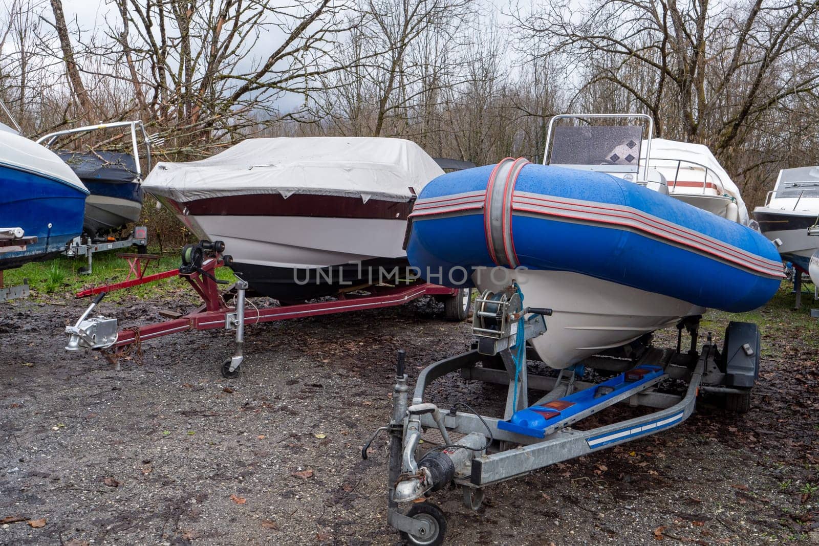 two motor boats on trailers at a parking