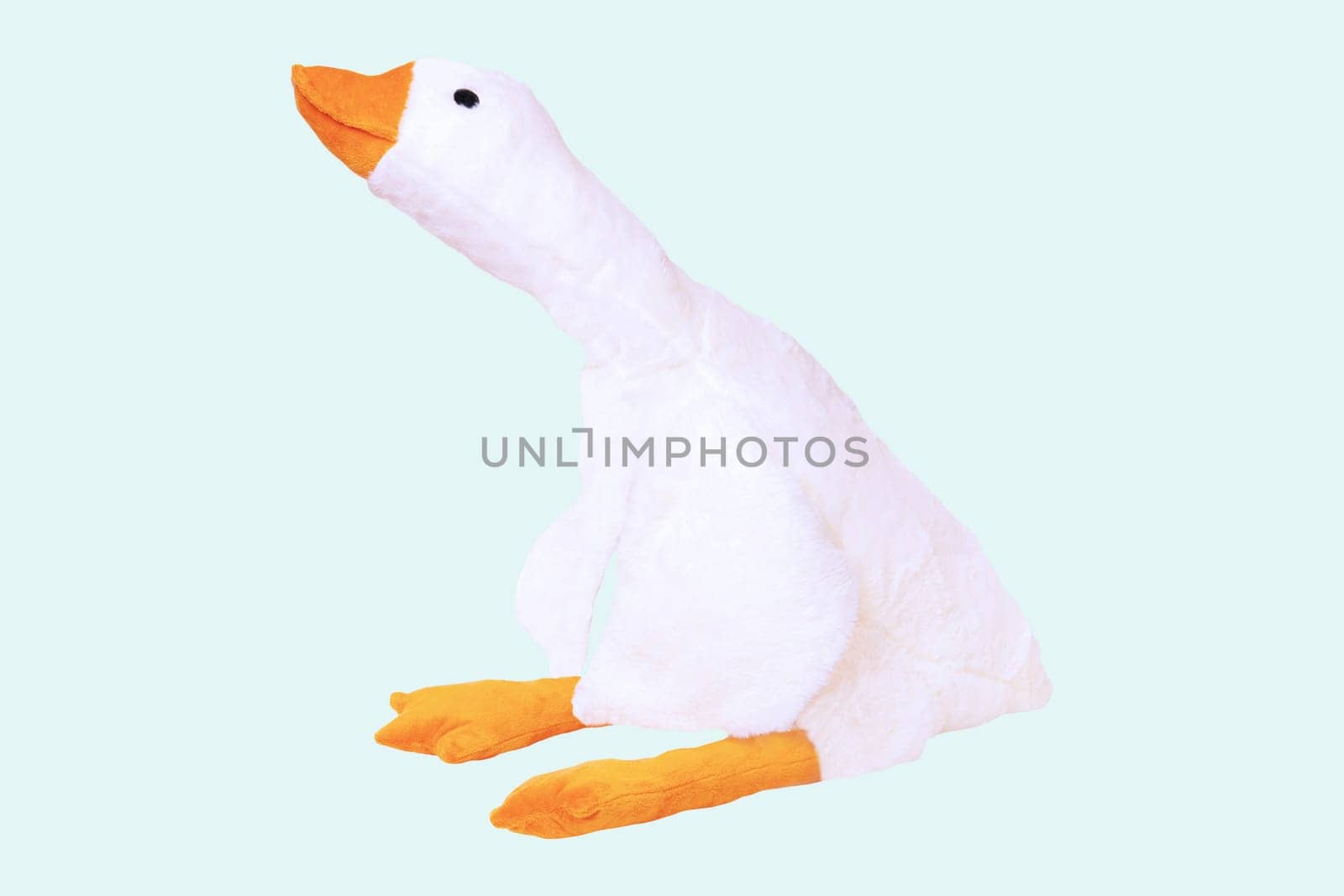 Childrens toy stuffed animals. Soft white plush toy duck for kids isolated on a light blue background. Duck teddy toy. White duck for playing.