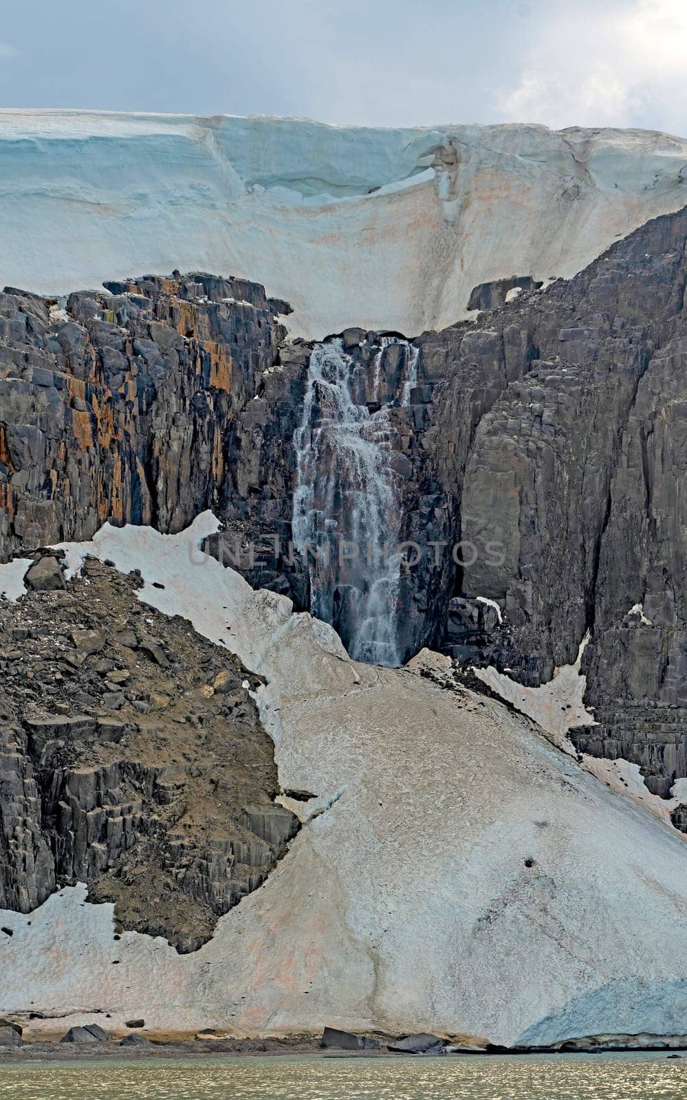 Massive Waterfall From a Melting Coastal Glacier at Alkefjellet in the Svalbard Islands