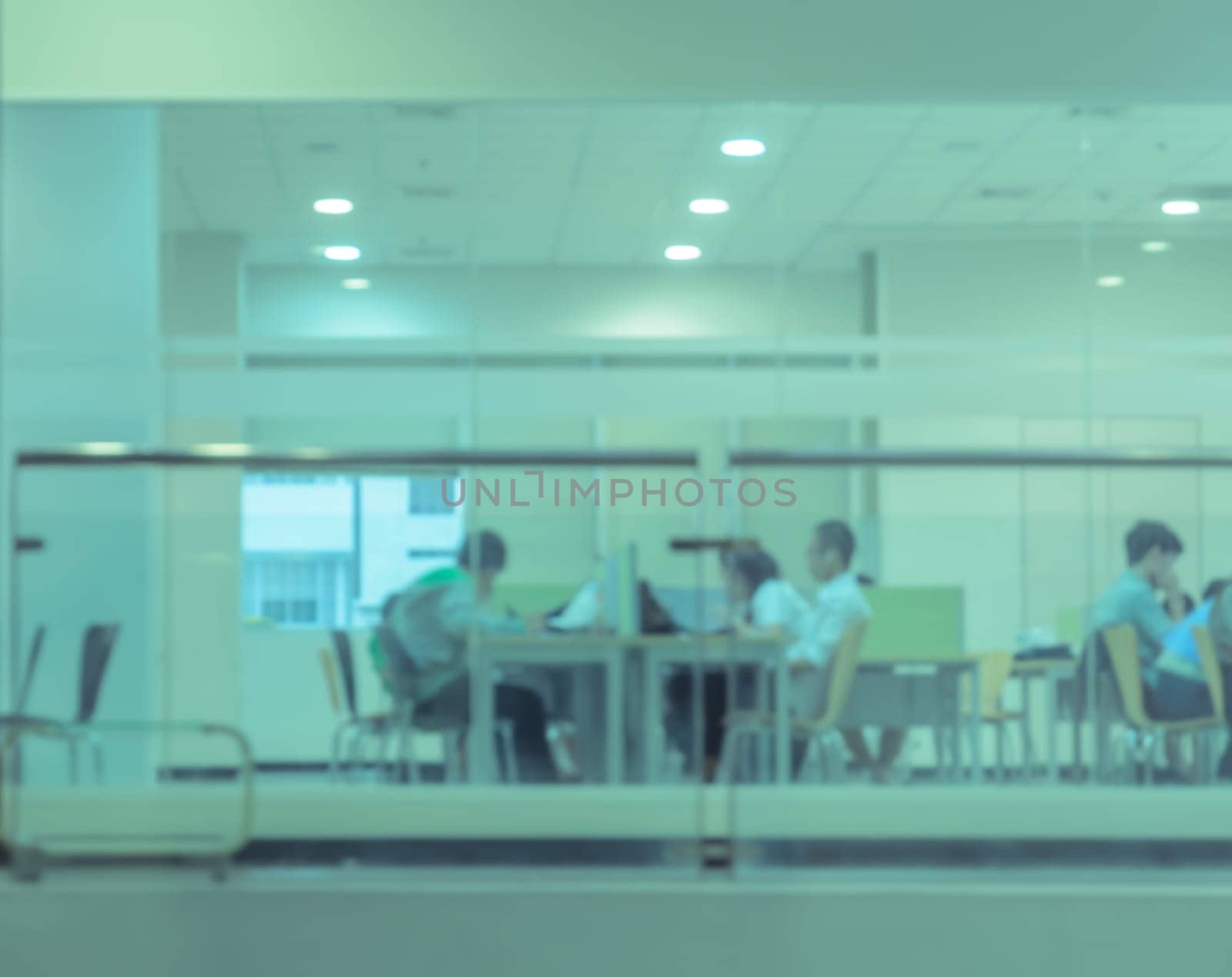 Blurry reading area in public library. Green toned image.