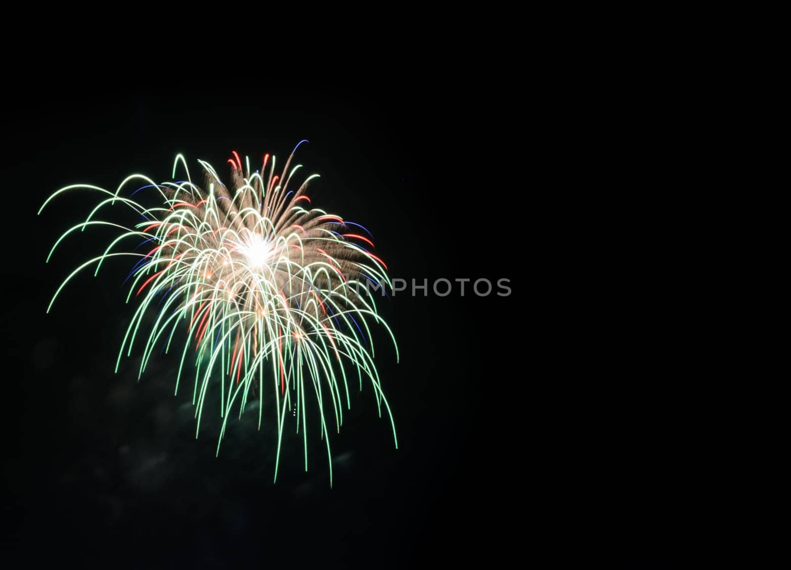 Colorful fireworks exploding in the night sky with copy space