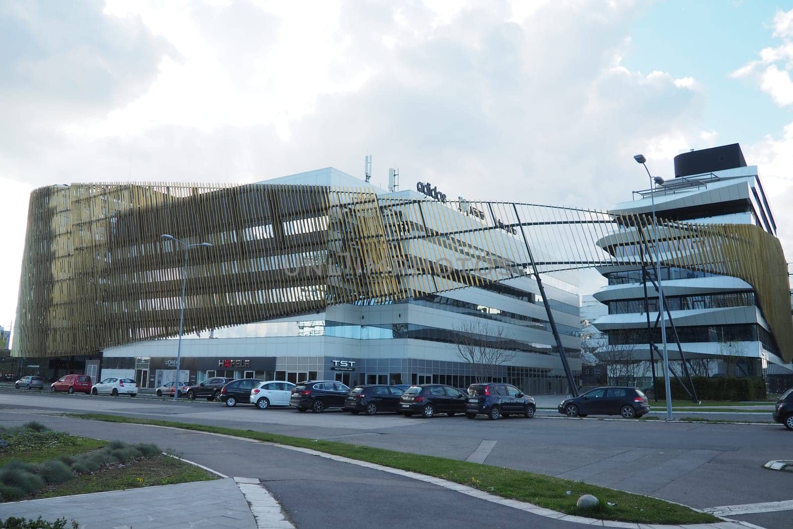 Belgrade, Serbia, 03.17.24: Nordeus smart ecological building. Milutin Milankovic Boulevard. Modern fashionable architecture with green initiatives. A ship-shaped house with glass walls and terraces.