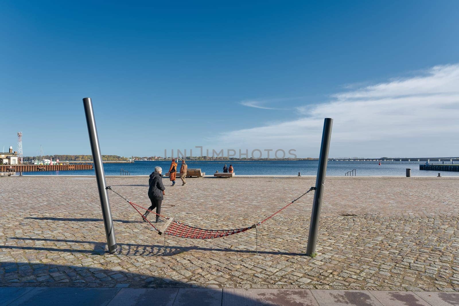 Hammock and some tourists on the renovated harbor promenade of Stralsund on the Strelasund in Germany
