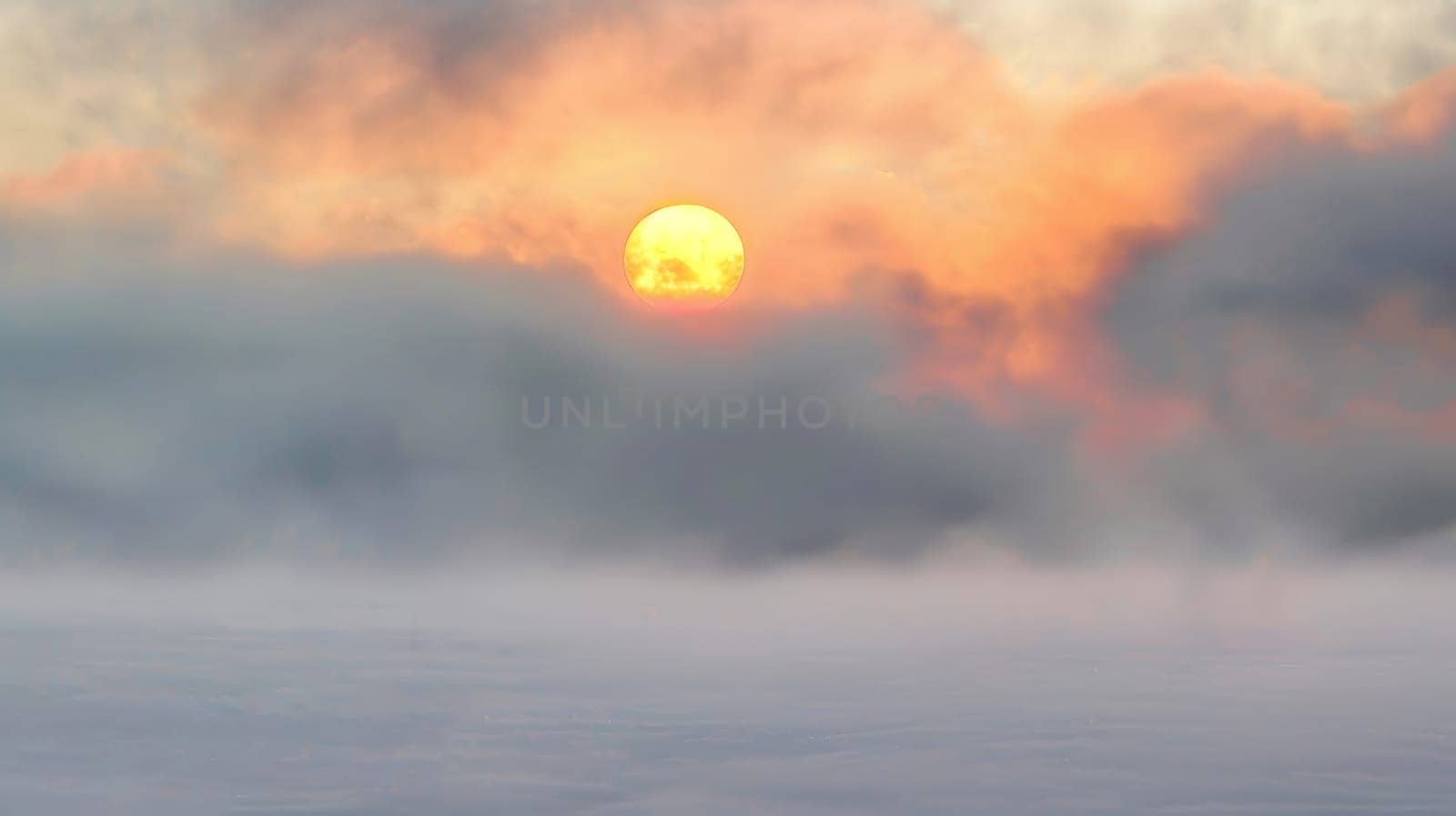 Captured amidst a mystical mist, this ethereal photograph portrays the serene beauty of a sunset shrouded in fog, evoking a sense of mystery and tranquility.