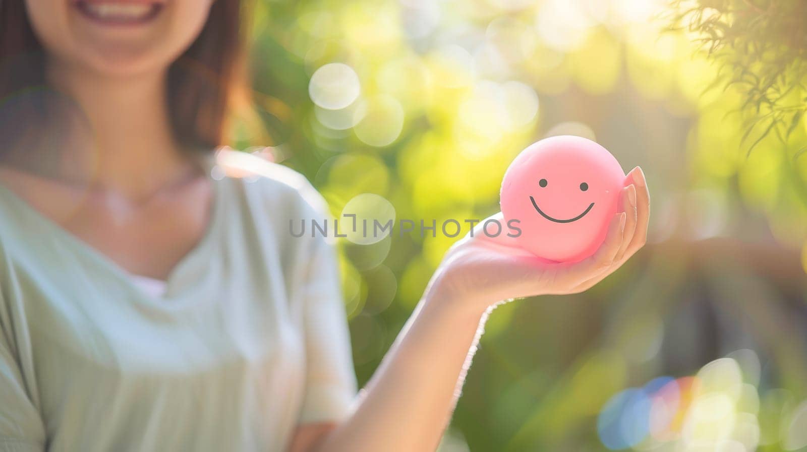 In this photo, a woman's hand tenderly holds a happy smile sphere, symbolizing the importance of positive thinking and mental health assessment. It embodies the essence of World Mental Health Day, advocating for well-being and happiness.