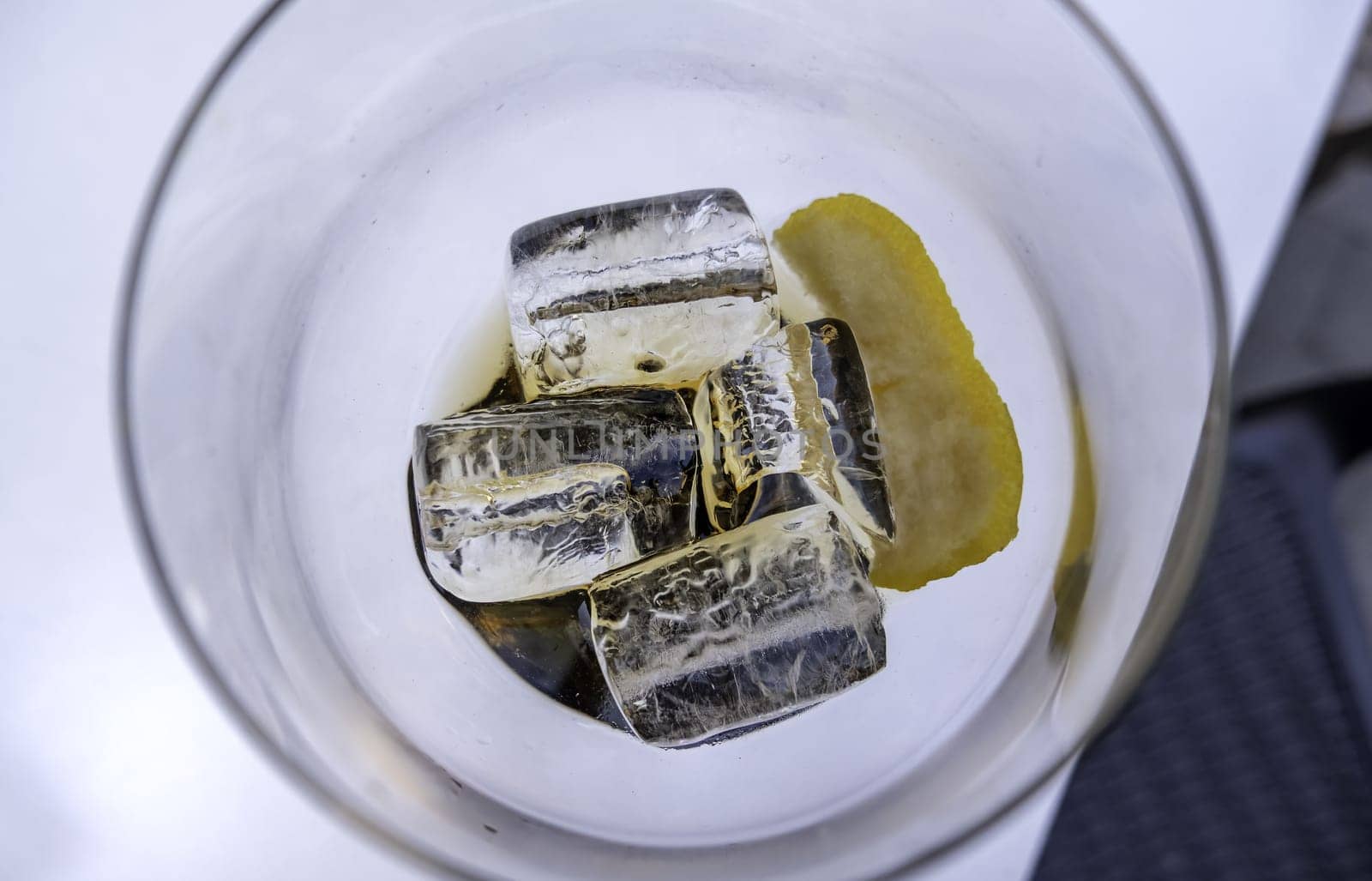 Detail of glass cup with ice, alcoholic drink, soft drink and party