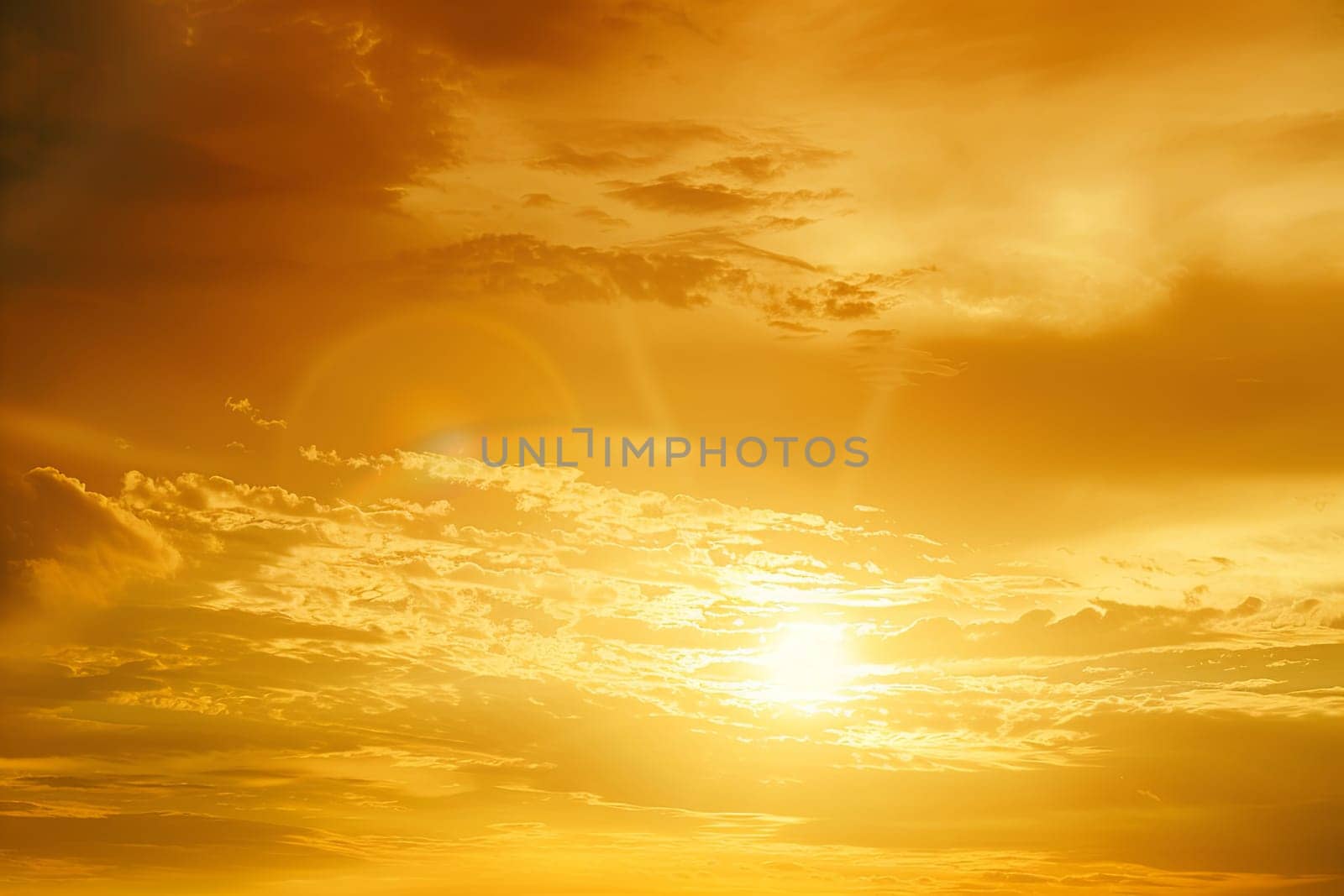 The sun is gradually disappearing behind thick clouds as it sets in the sky. The clouds are casting shadows, creating a dramatic and moody atmosphere.
