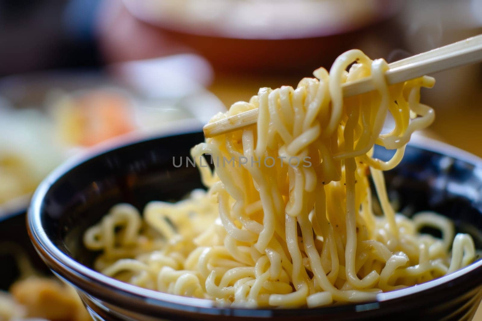 A close-up view of a bowl filled with steaming noodles, topped with slices of vegetables and meat, accompanied by a pair of chopsticks ready to be used.