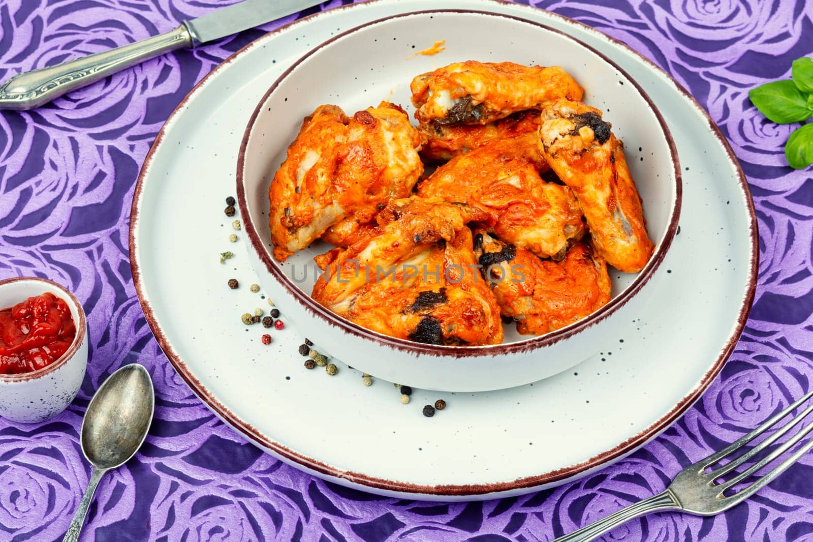 Grilled spicy chicken wings with ketchup on a plate. Baked chicken wings BBQ.