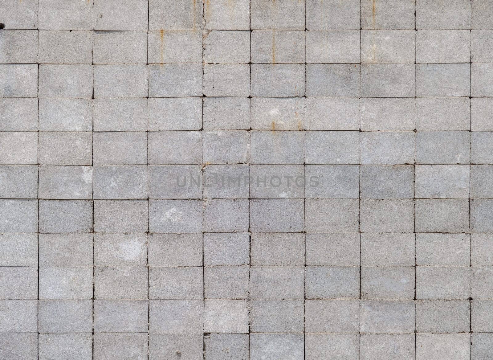 Wall made of rectangular cinder blocks with stack bond checkered pattern. Full-frame flat background and texture.