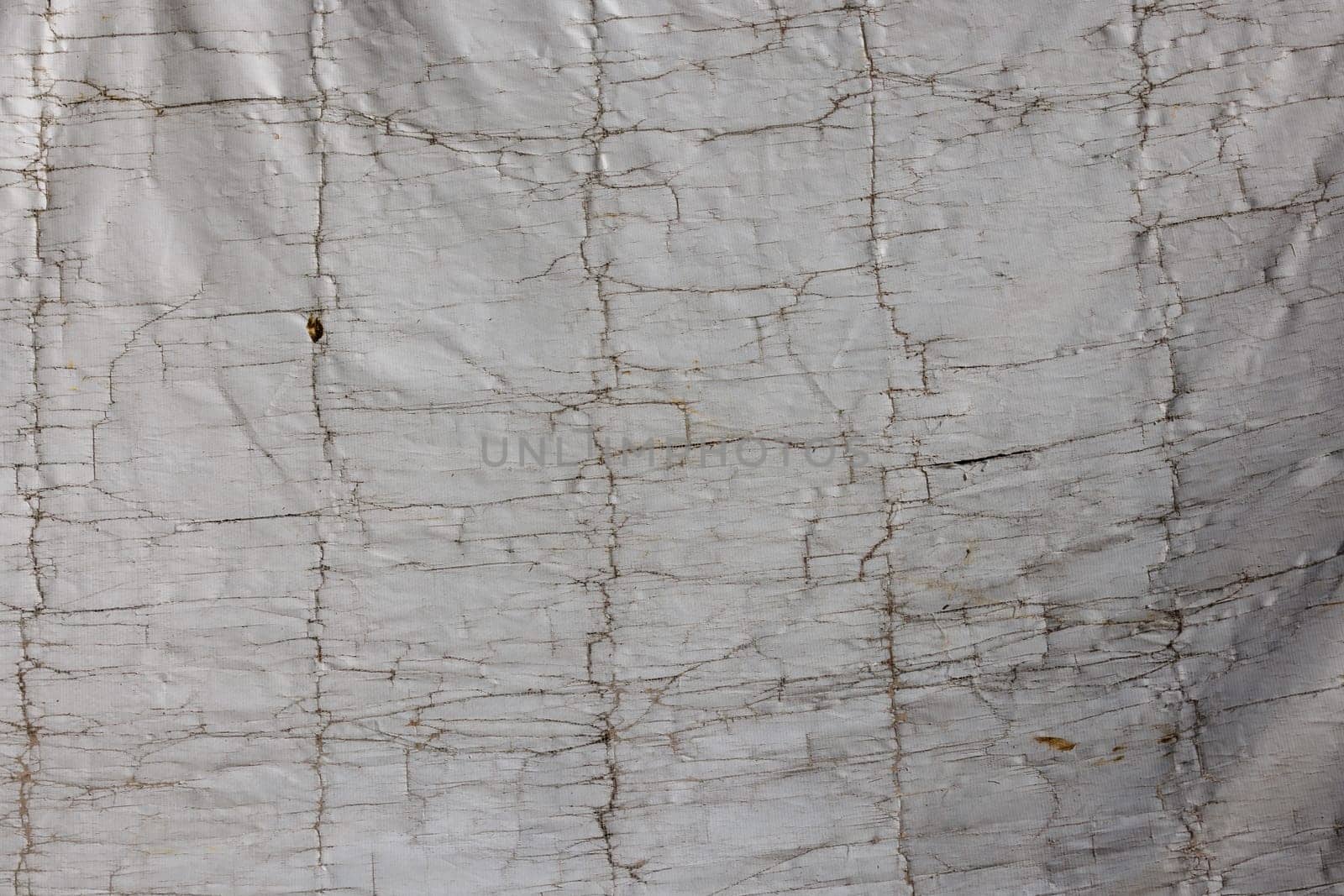 Old cracked white building cover tarp, full-frame background and texture.