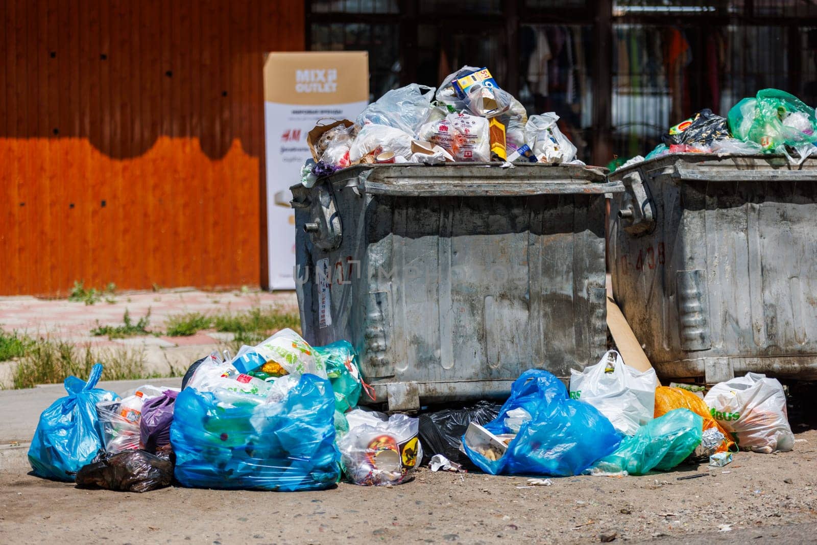overfilled public trash bins at summer day in Bishkek, Kyrgyzstan - May 26, 2023