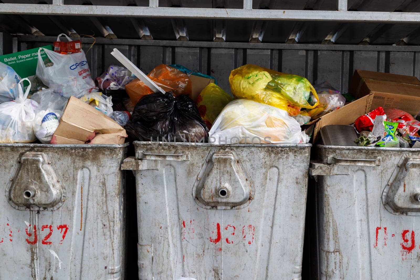 overfilled public trash bins at summer day in Bishkek, Kyrgyzstan - May 24, 2023