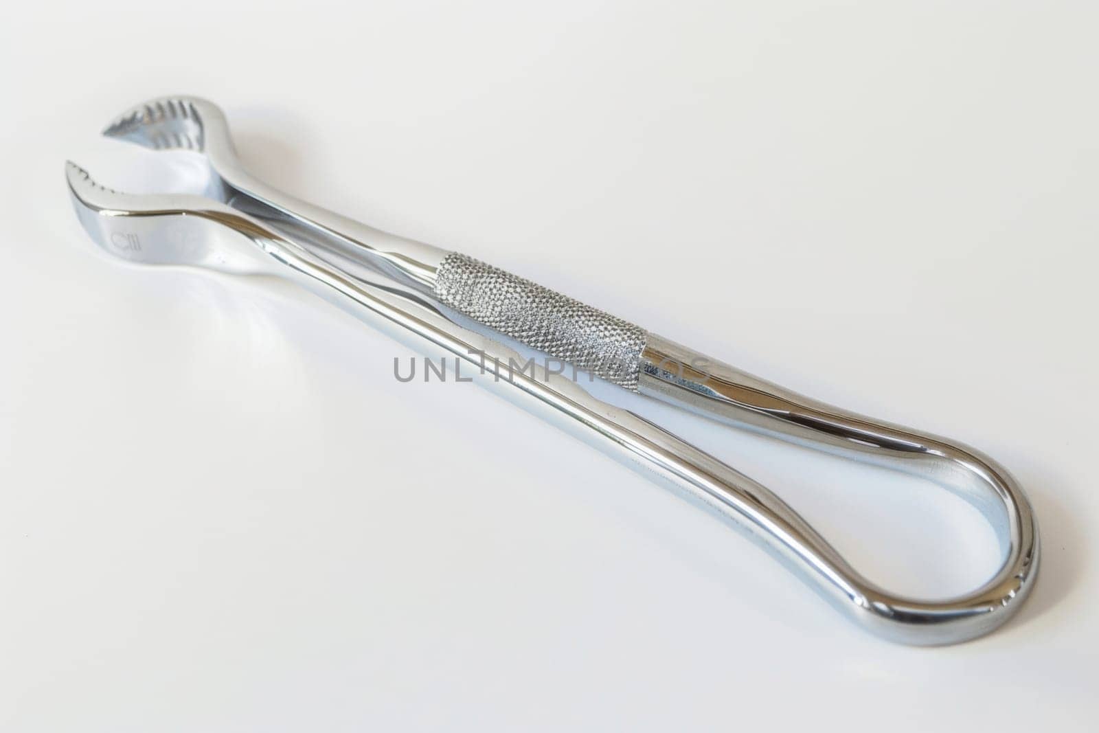 This close-up shot showcases a toothbrush lying on a clean white surface. The bristles and handle of the toothbrush are prominently featured, highlighting its design and functionality.