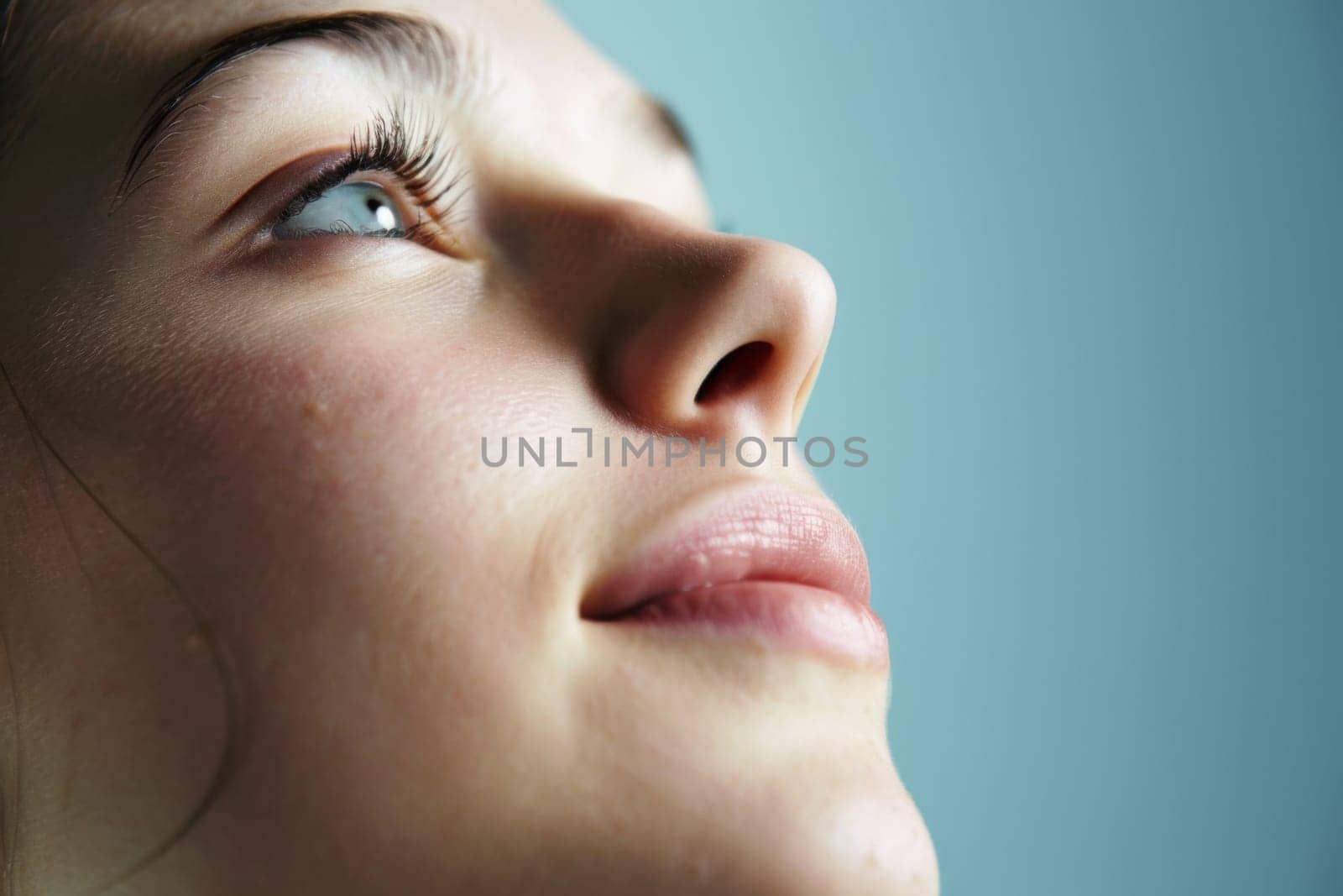 In the close-up shot, a womans face is centered, with her eyes closed. Her features are relaxed, and she appears to be in a state of calmness.