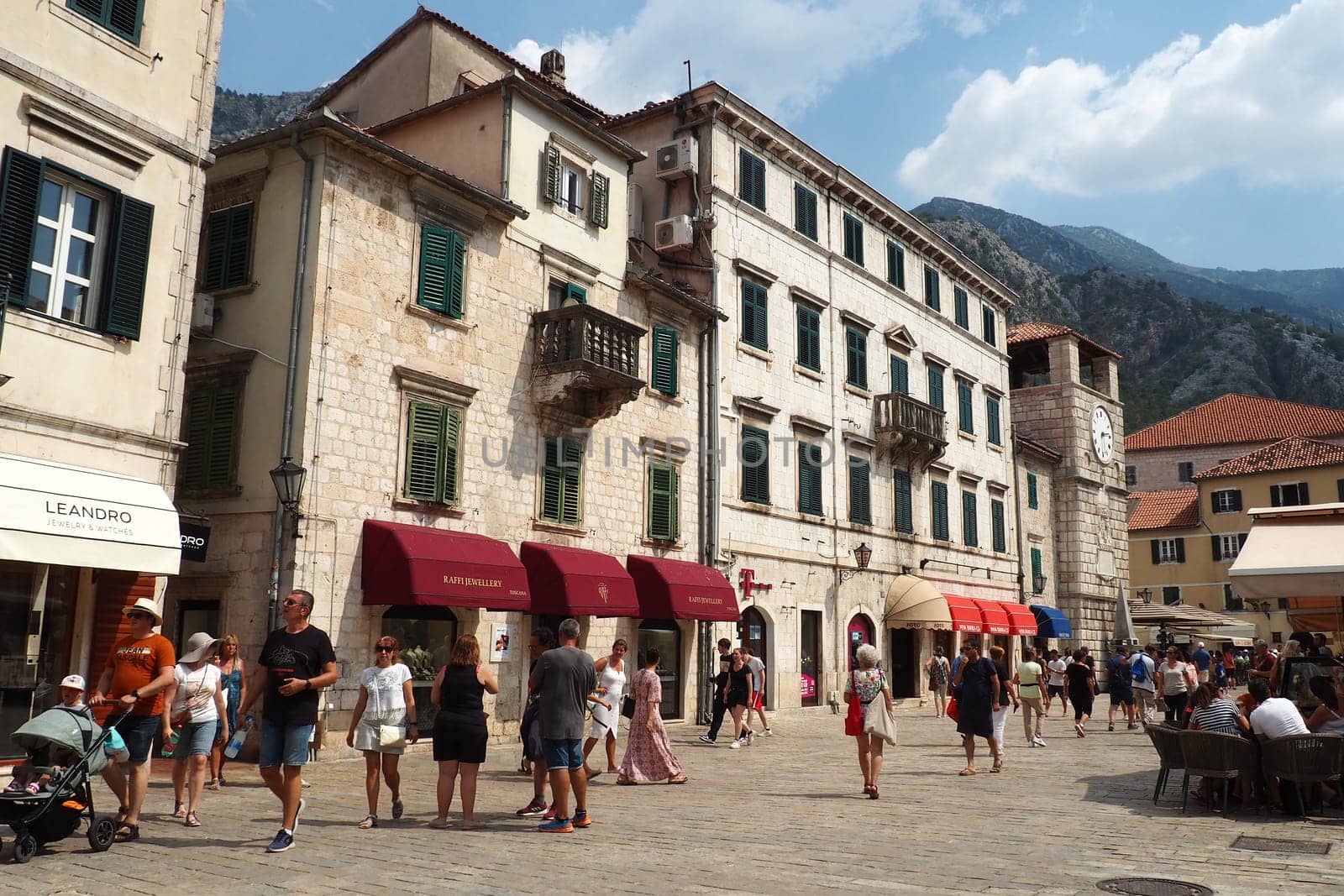 Kotor, Montenegro, 08.11.22: Trg od Oruzja, Arms Square, town square in old city. Square of the Arms. Tourists, women and men, walk along paving stones. Restaurants, souvenir shops. Excursion tourism