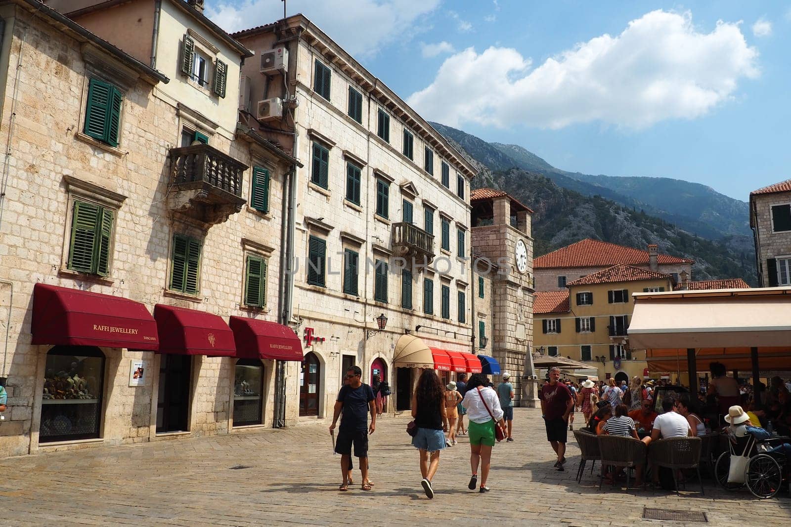 Kotor, Montenegro, 08.11.22: Trg od Oruzja, Arms Square, town square in old city. Square of the Arms. Tourists, women and men, walk along paving stones. Restaurants, souvenir shops. Excursion tourism