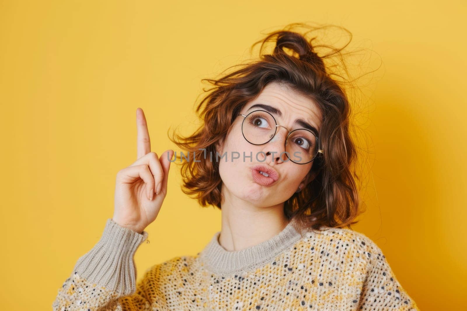 A woman wearing glasses is seen making a peace sign gesture with her hand. She is smiling and looking directly at the camera. The background is plain and unobtrusive.
