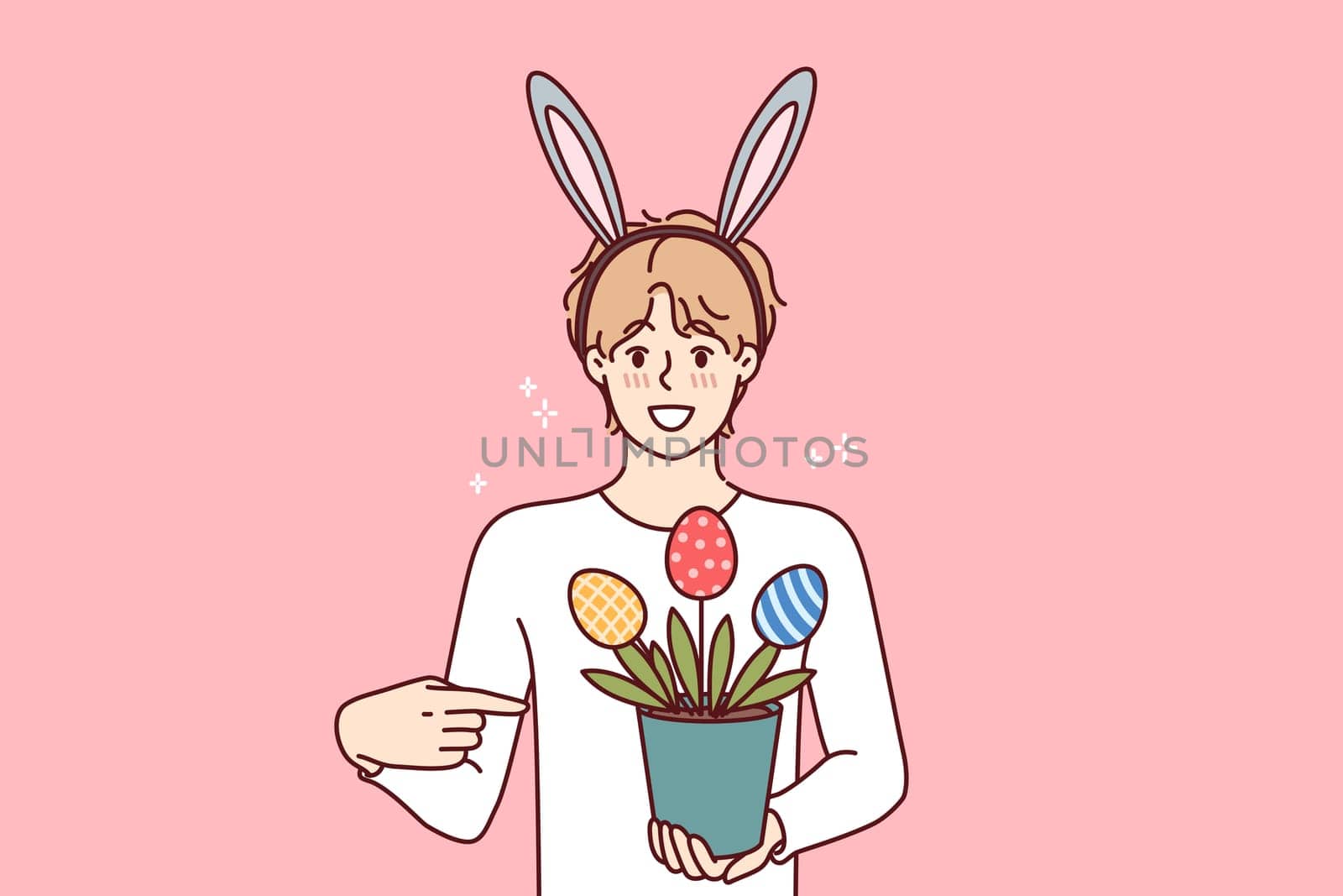 Guy celebrating easter holds pot of plants in shape of multi-colored eggs, wears bunny ears on head