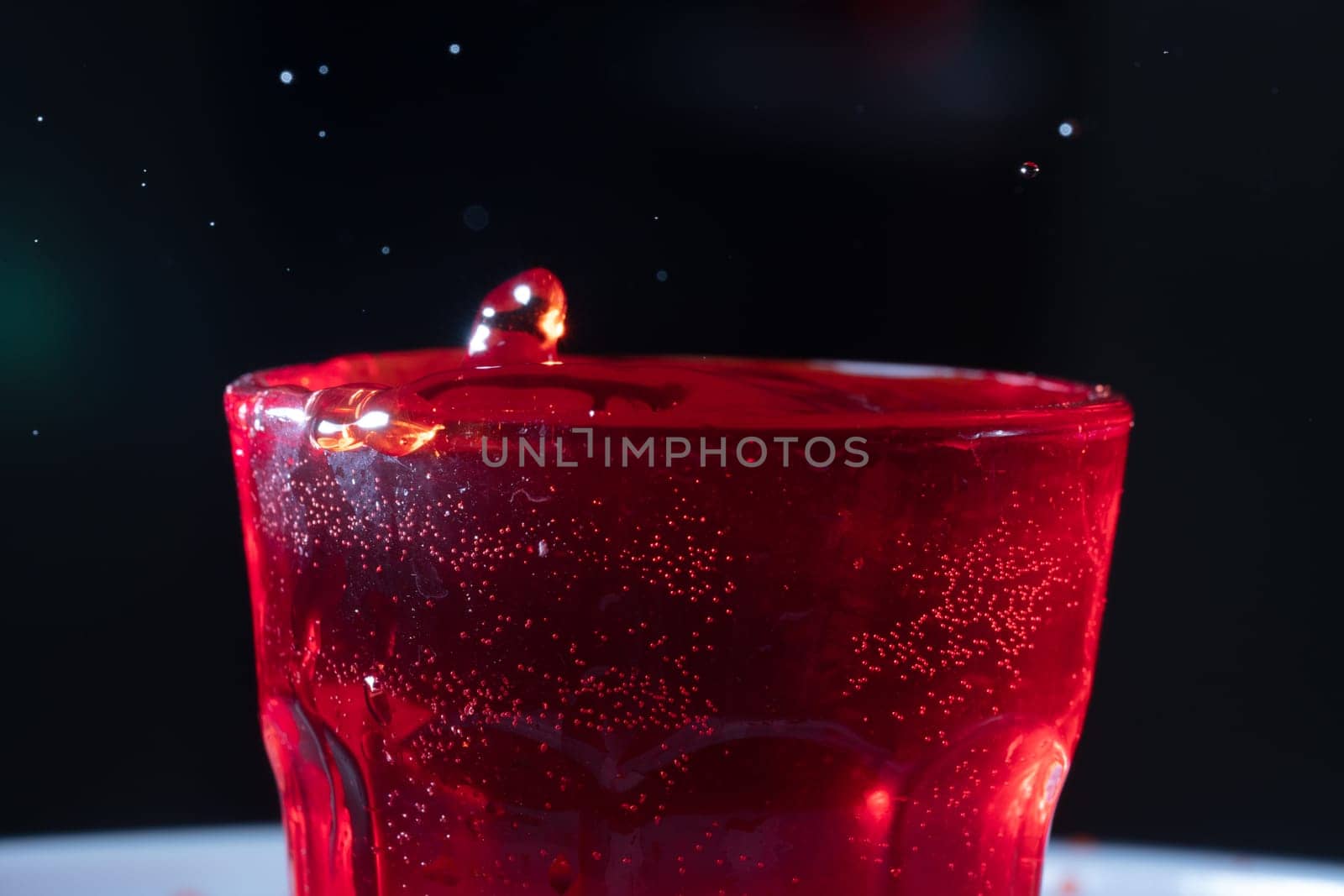 drops of red liquid in glass beaker