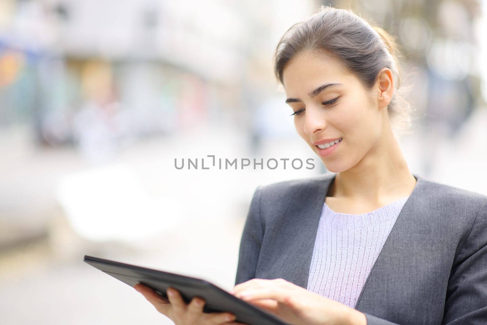 Executive using tablet standing in the street