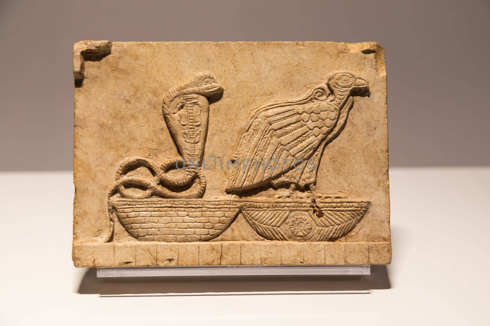 Turin, Italy - 28 December 2023: Egyptian Museum. Plaque with vulture and cobra, limestone, 400 BC