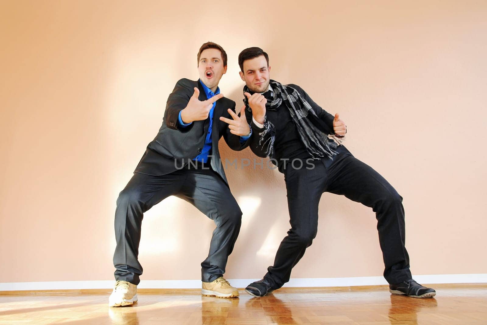 Two boastful men in suits make gestures with their hands