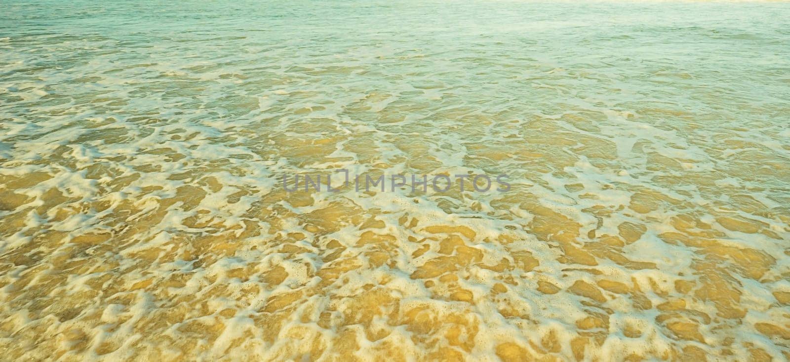 Ocean background of shallow sea water foaming and churning sand
