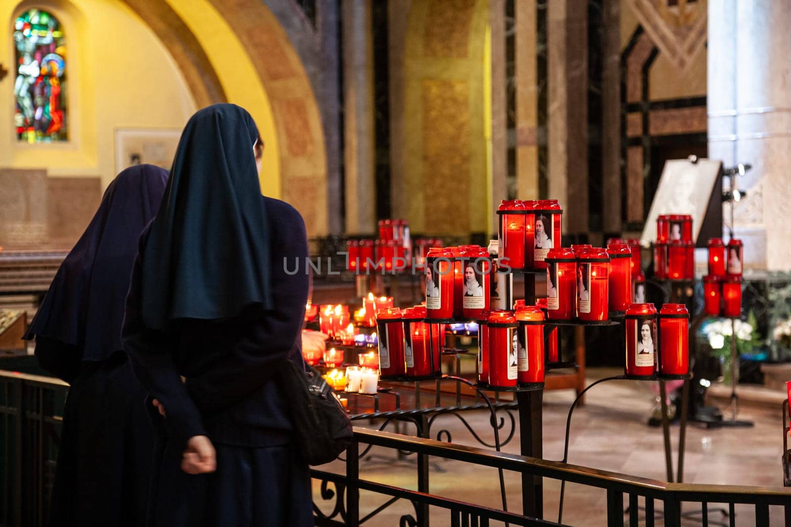 Lourdes, France - april 08 2010 : Back view of nuns in traditional robes pray in a Christian Basilica in Lourdes, France