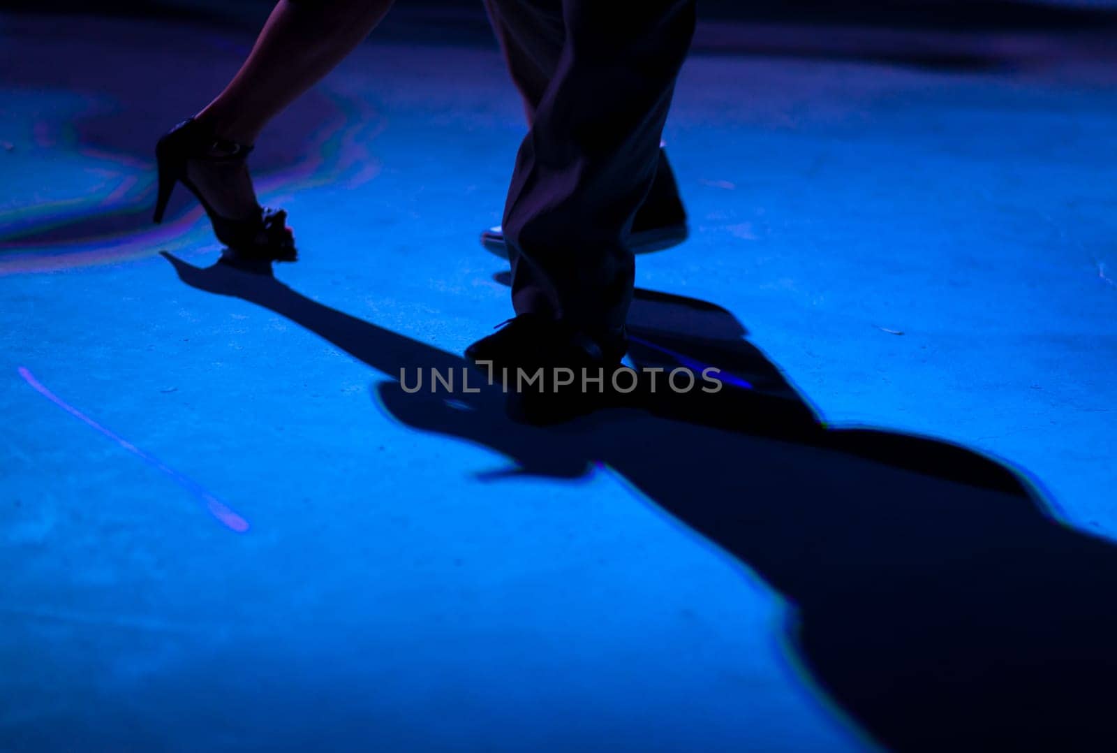 Detail of shoes with shadows in milonga ballroom.