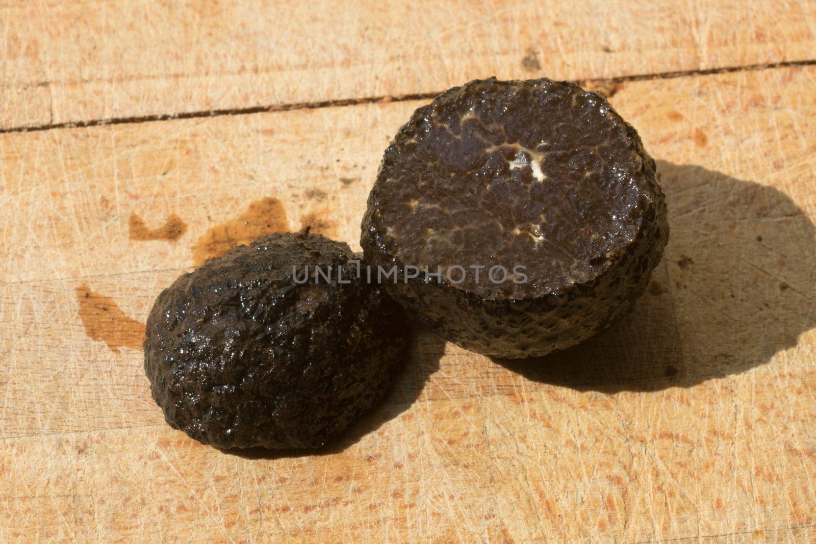 Tomato and black truffle isolated on a wooden cutting board