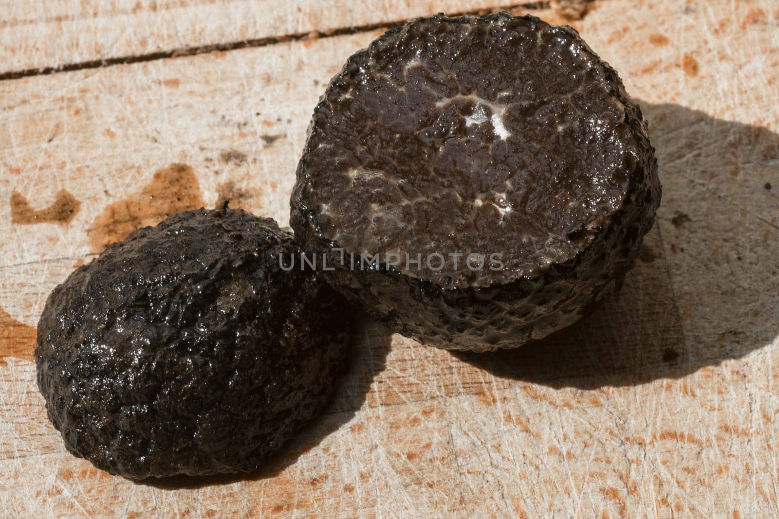 Tomato and black truffle isolated on a wooden cutting board