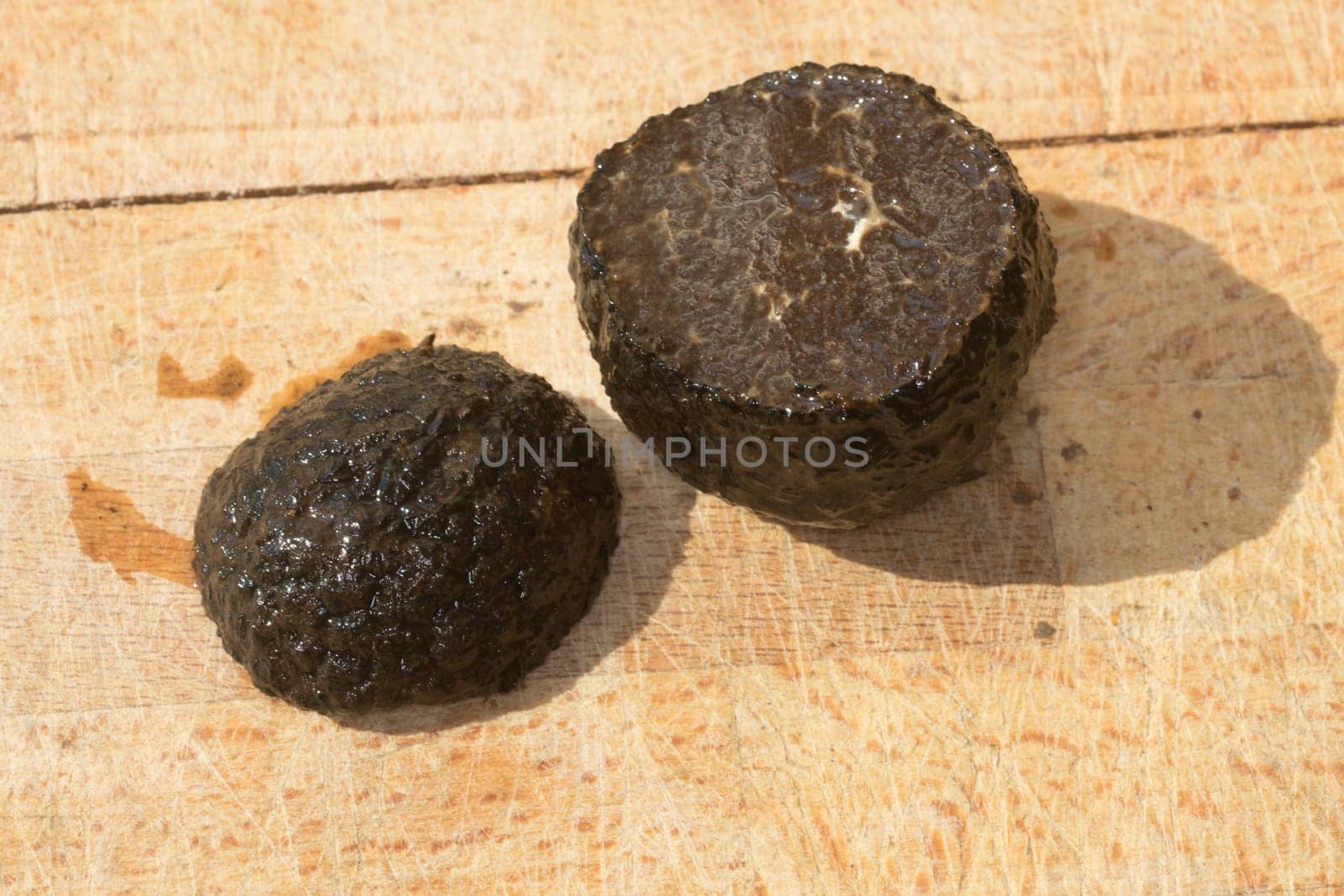 Tomato and black truffle isolated on a wooden cutting board