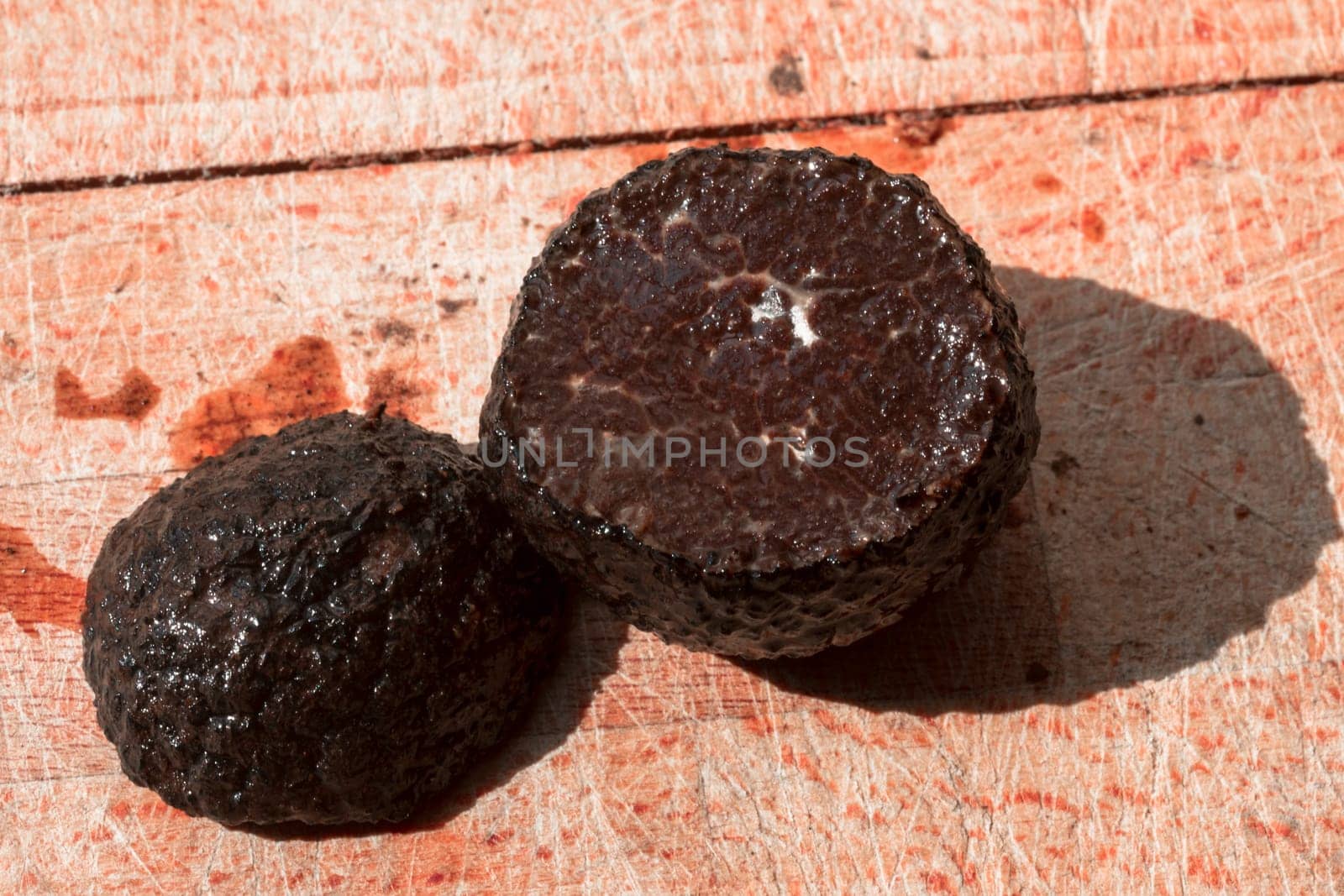 Tomato and black truffle isolated on a wooden cutting board