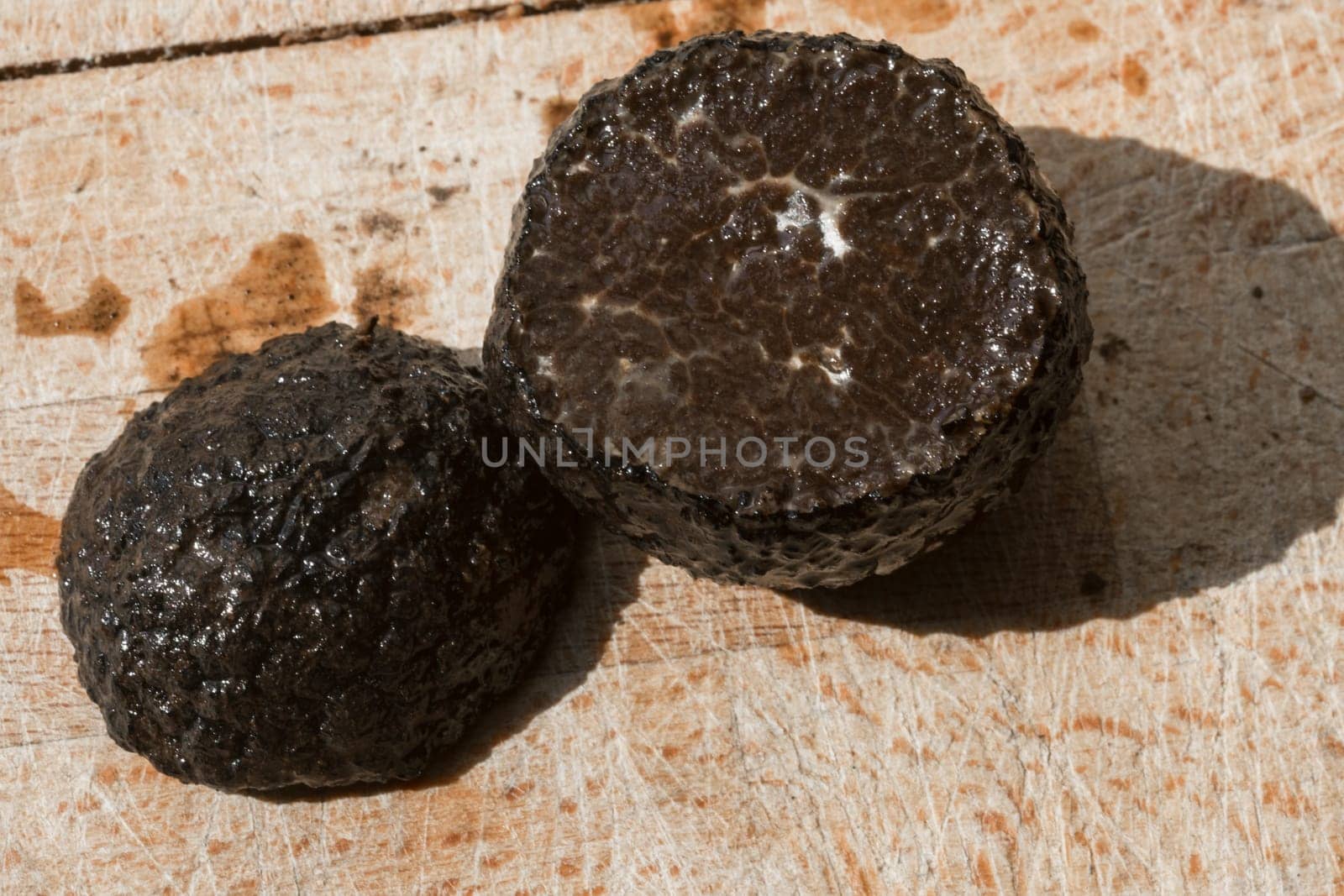 Tomato and black truffle isolated on a wooden cutting board