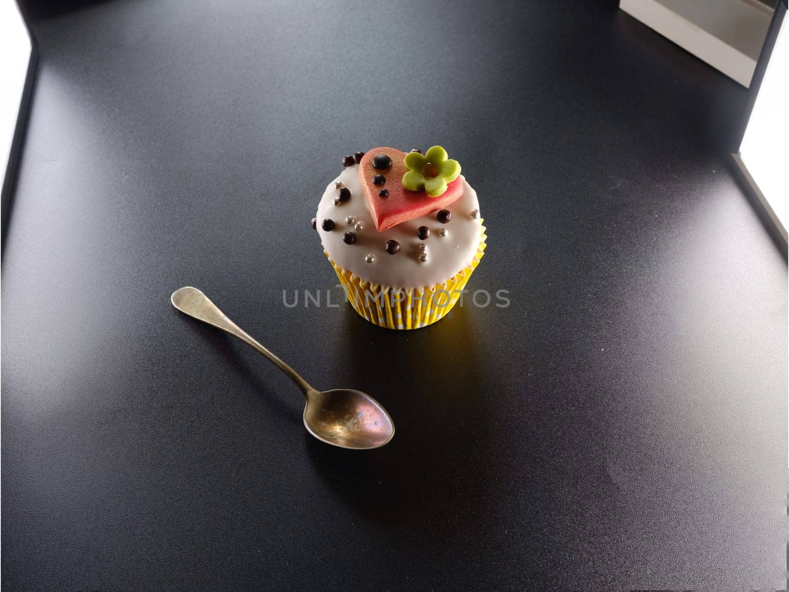 A delicious cupcake with heart on a black backround